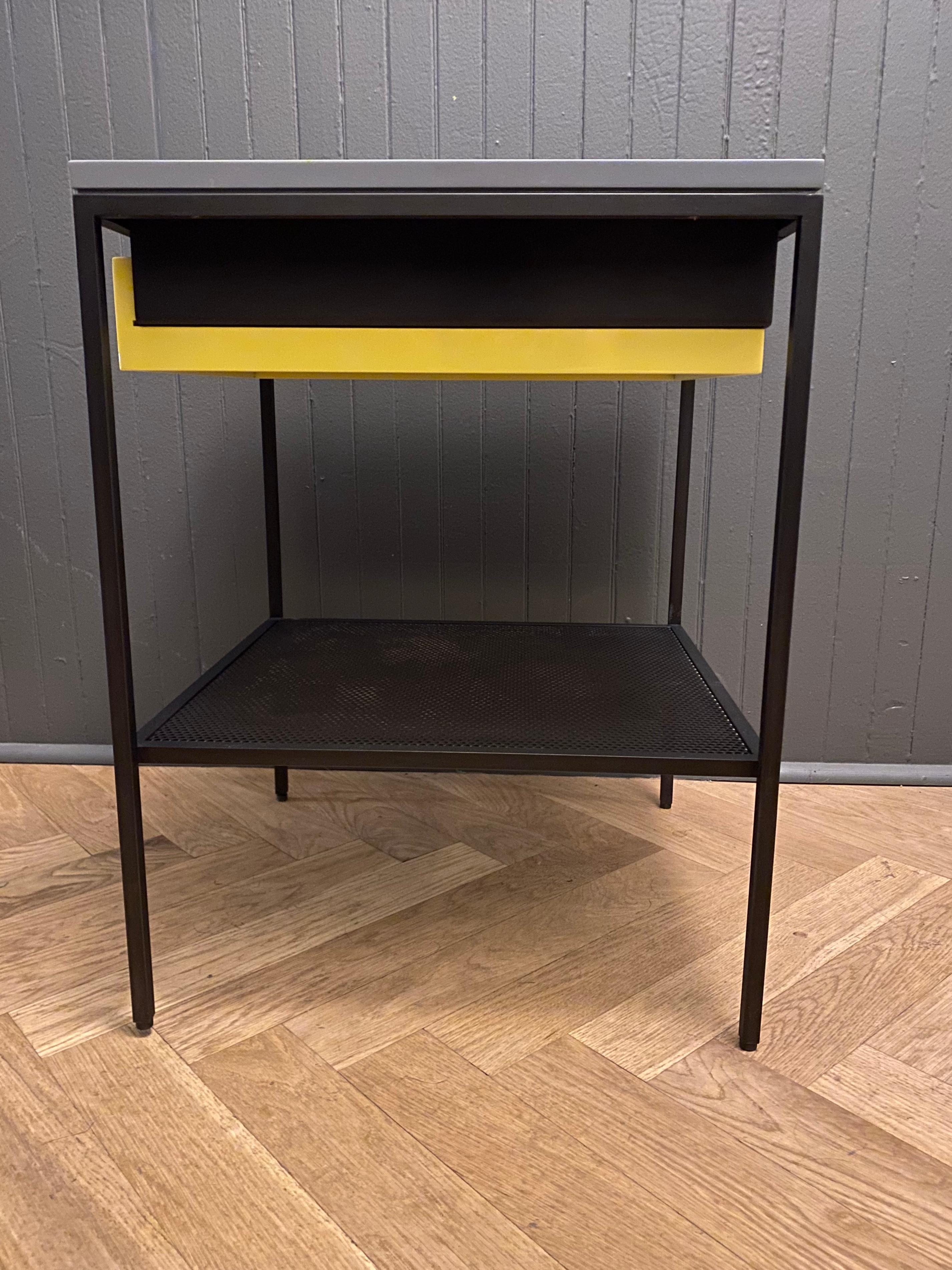Lacquered components on a blackened steel frame with perforated wire shelf. Single table in stock as shown with gray top and yellow drawer or made to order.