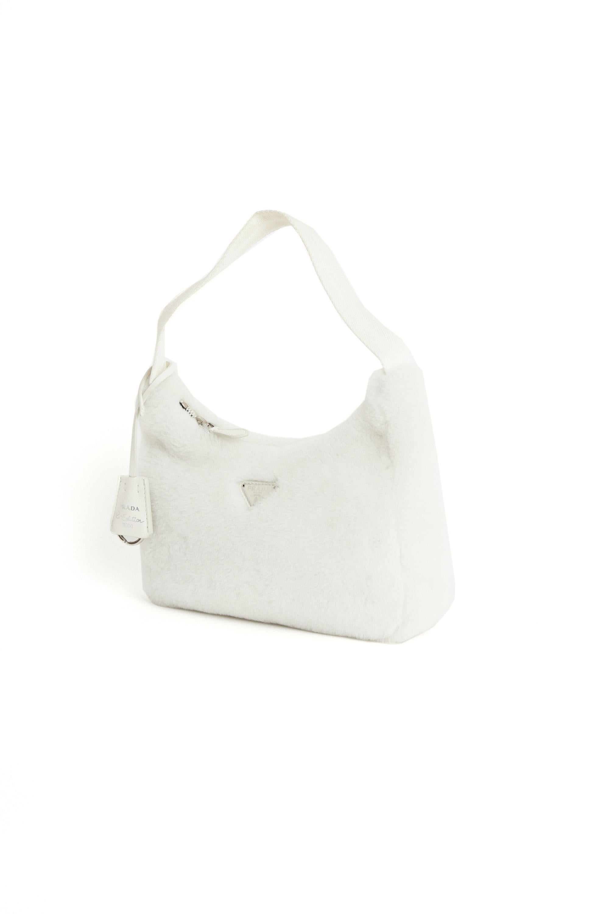 Prada re-edition white shearling hobo bag. Features a keychain and zip closure. Pre-loved, in excellent vintage condition.

Brand:Prada
Color: White
Hobo bag
Fabric: Shearling, Leather
Dustbag: Yes
Authentication card: No
Serial number: