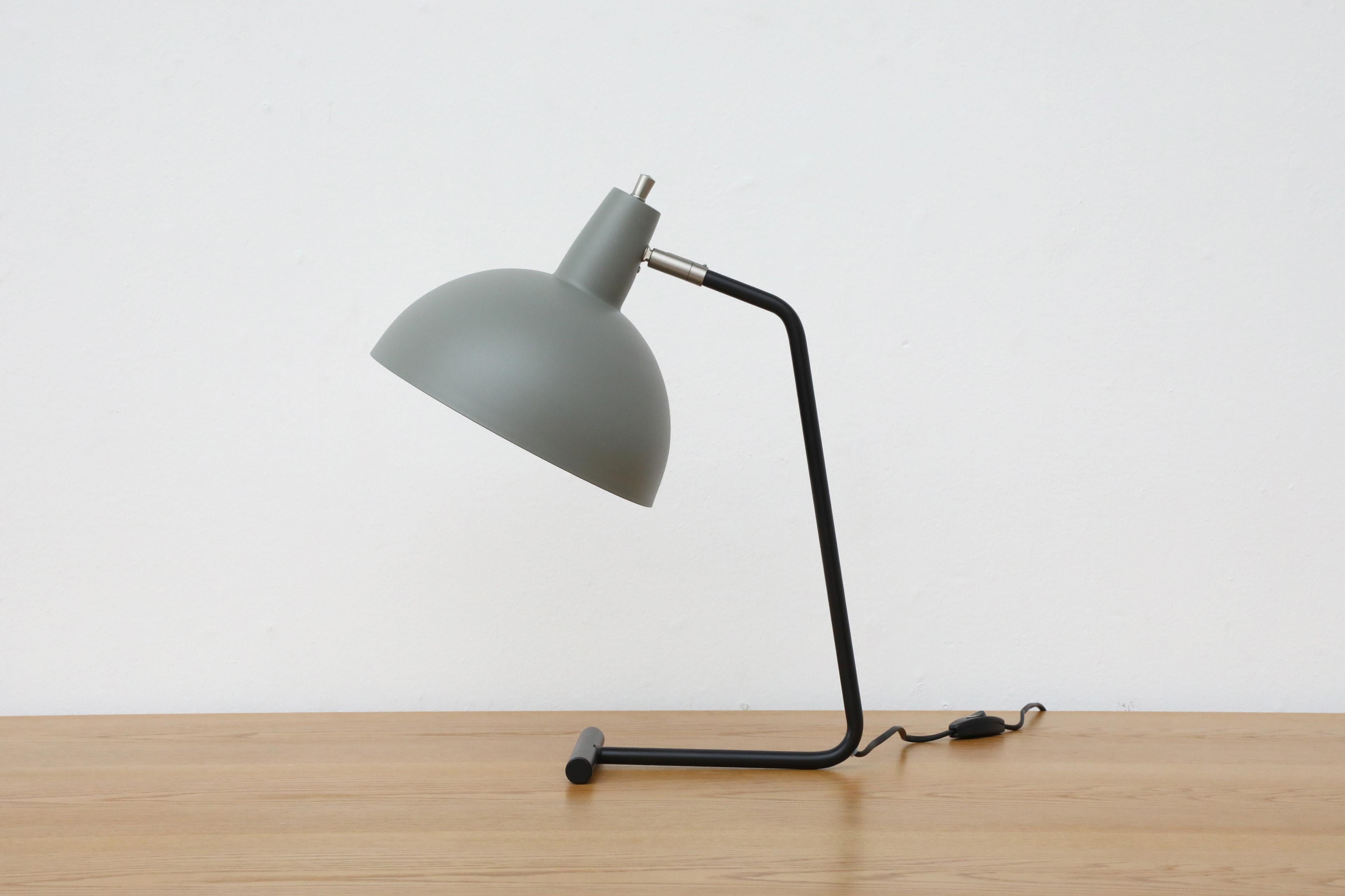 A new production of the iconic Anvia No. 1501 'The Director' table lamp in grey. Classic Dutch design with grey dome shade and black enameled frame. Attractive lines with rotating shade and chrome accents. In original condition with wear consistent