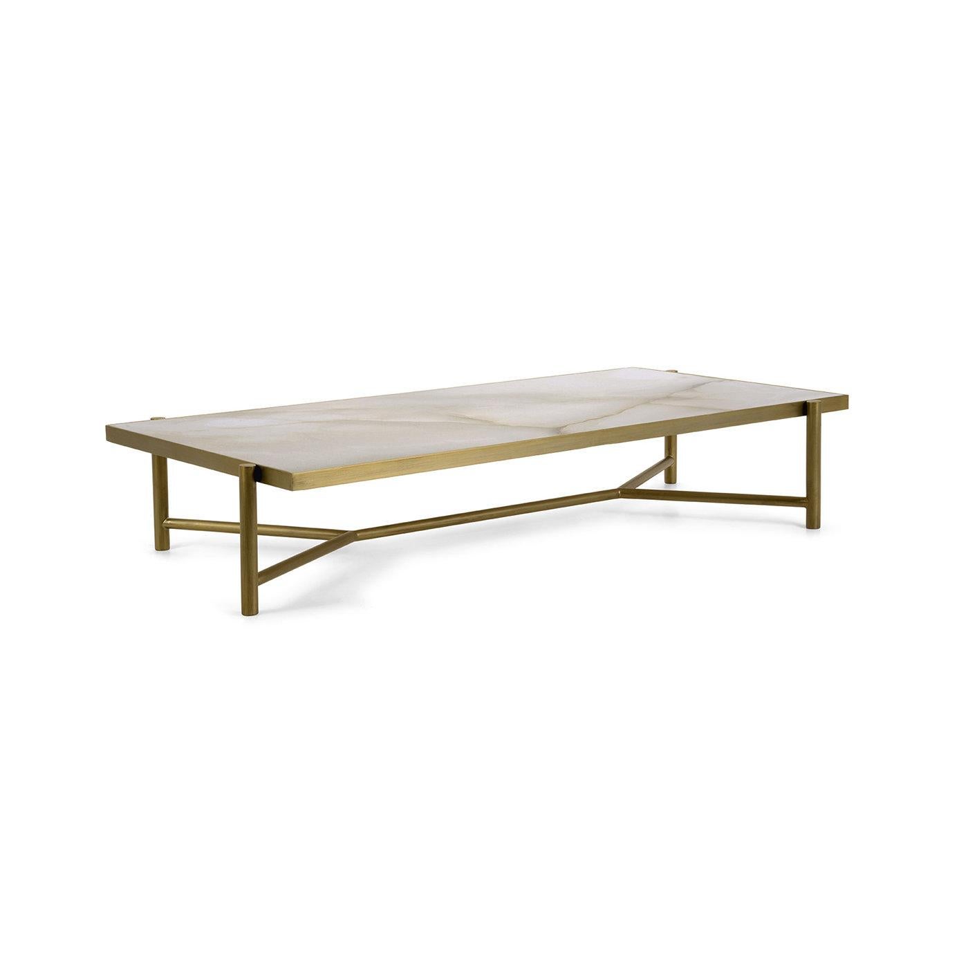 Refined in its rigorous simplicity, this glamorous coffee table is part of a collection inspired by Rhea, Titaness and mother of Zeus in Greek mythology. The dynamic metal structure with a burnished brass finish comprises the legs sustaining the
