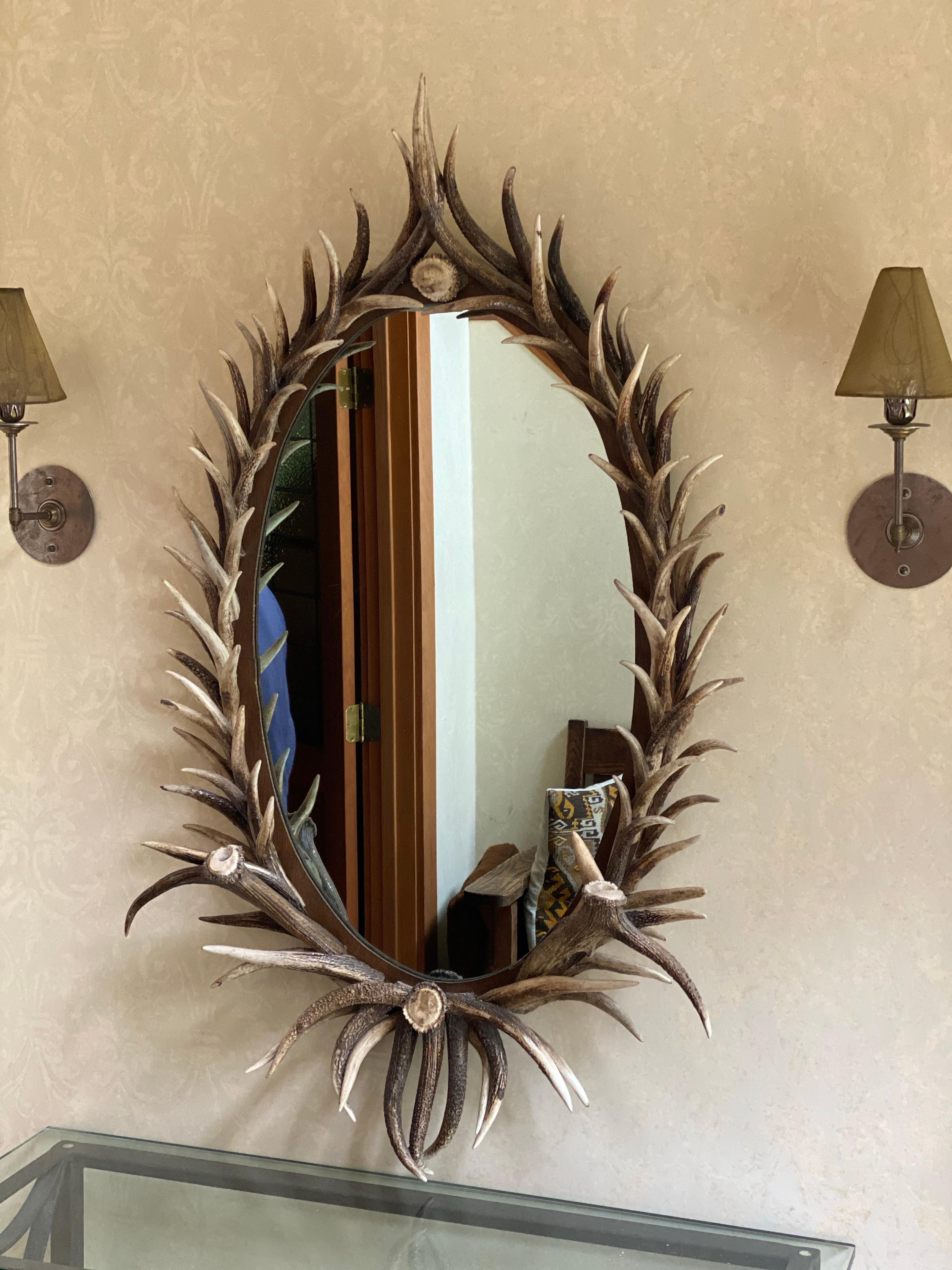 Real Antler Mirror in Oval Shape, Late 20th Century
This is a rustic decorative mirror framed with real antlers, likely deer or elk, creating an organic, textured border. The antlers vary in size and shape, and appear to be naturally shed, rather