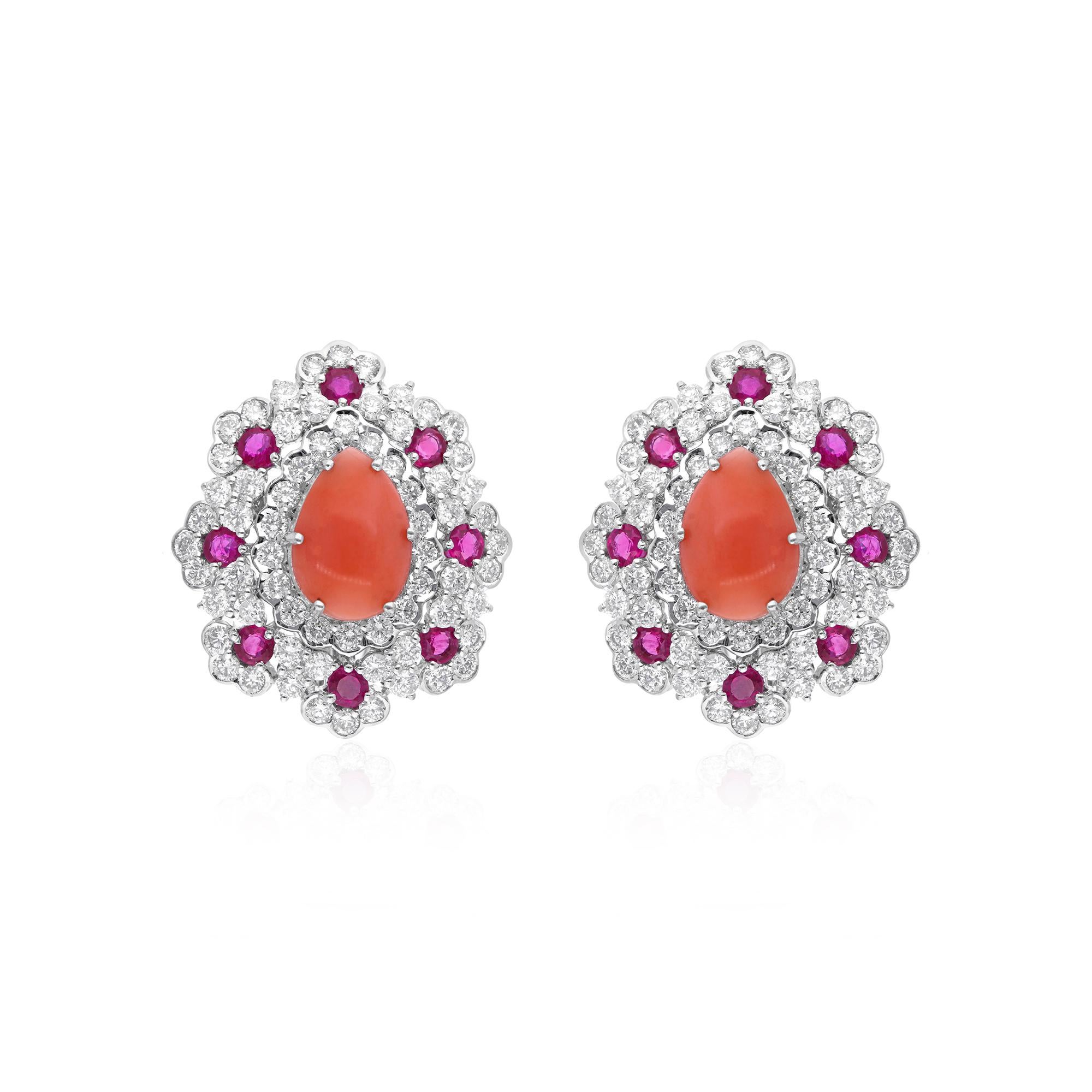 Set in the finest 14 karat white gold, these studs are a testament to luxury craftsmanship. The brilliance of the coral gemstones is accentuated by the surrounding array of dazzling rubies and diamonds. Each precious stone is carefully selected and
