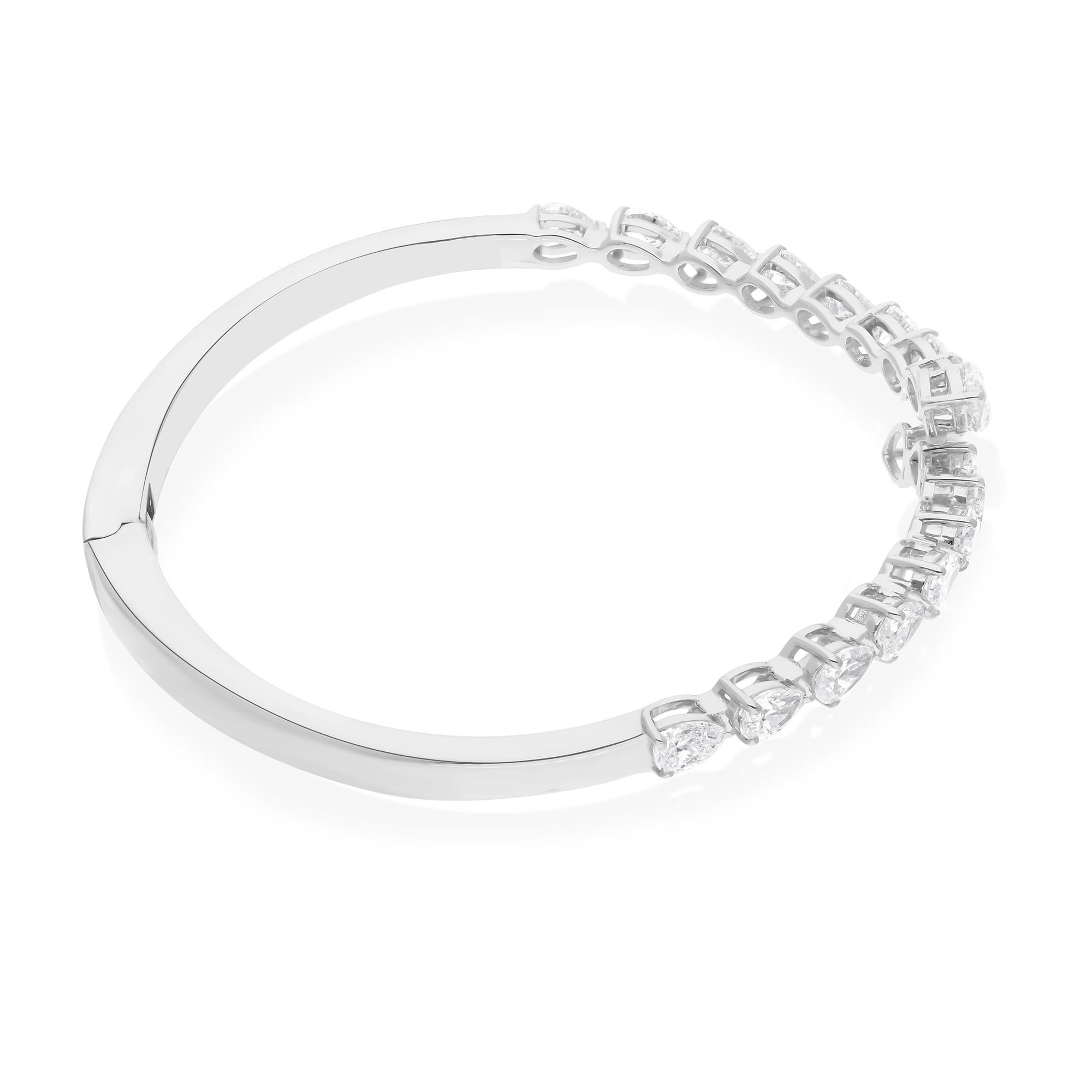 Crafted with meticulous attention to detail, this breathtaking cuff bangle bracelet features a stunning pear-shaped diamond at its focal point. Encased in lustrous 14 karat white gold, this timeless piece exudes elegance and sophistication.

Item