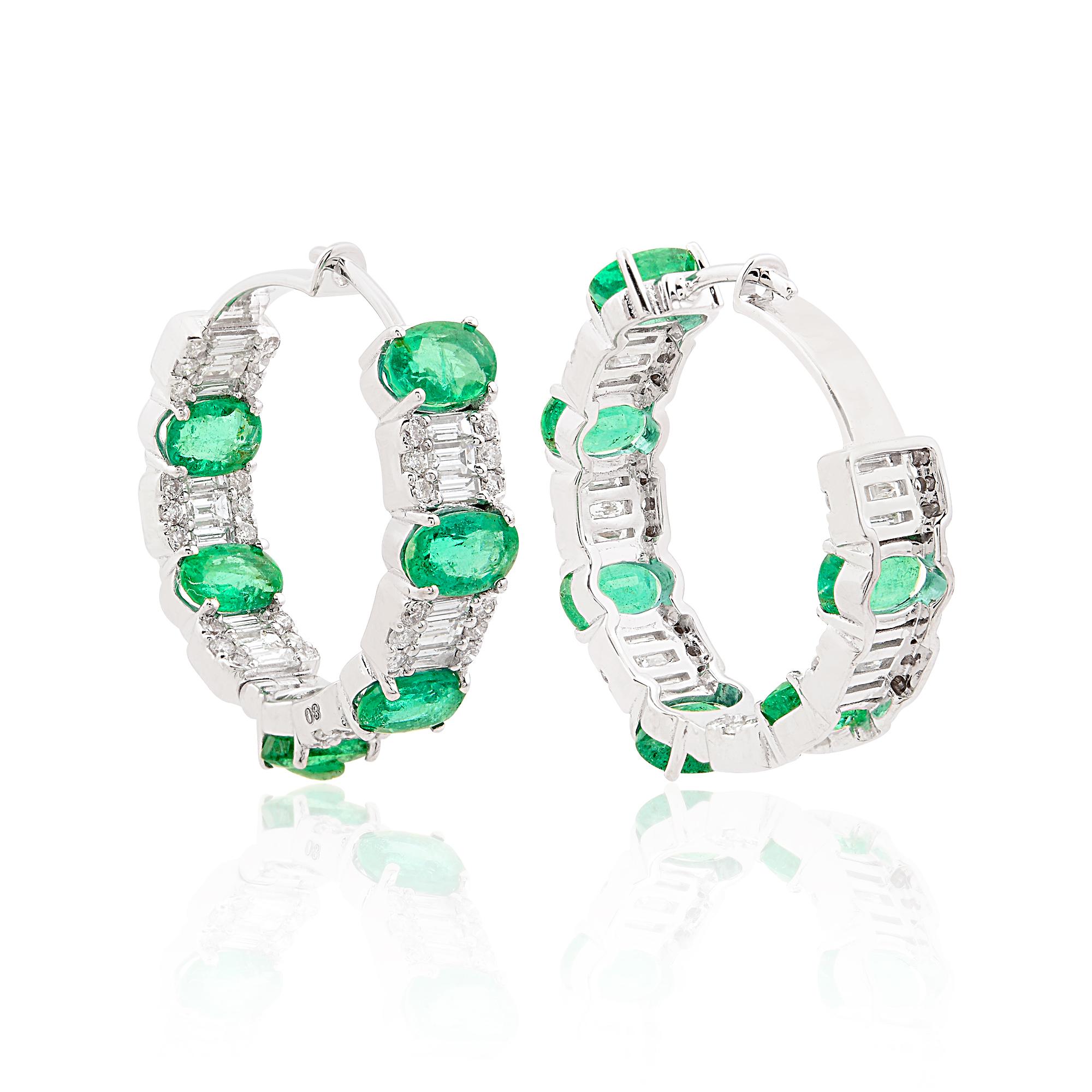 These striking gemstones are expertly set within hoops of 18 karat white gold, a metal renowned for its luminous sheen and timeless appeal. The intricate design of the hoops adds a touch of glamour and flair, enhancing the allure of the emeralds and