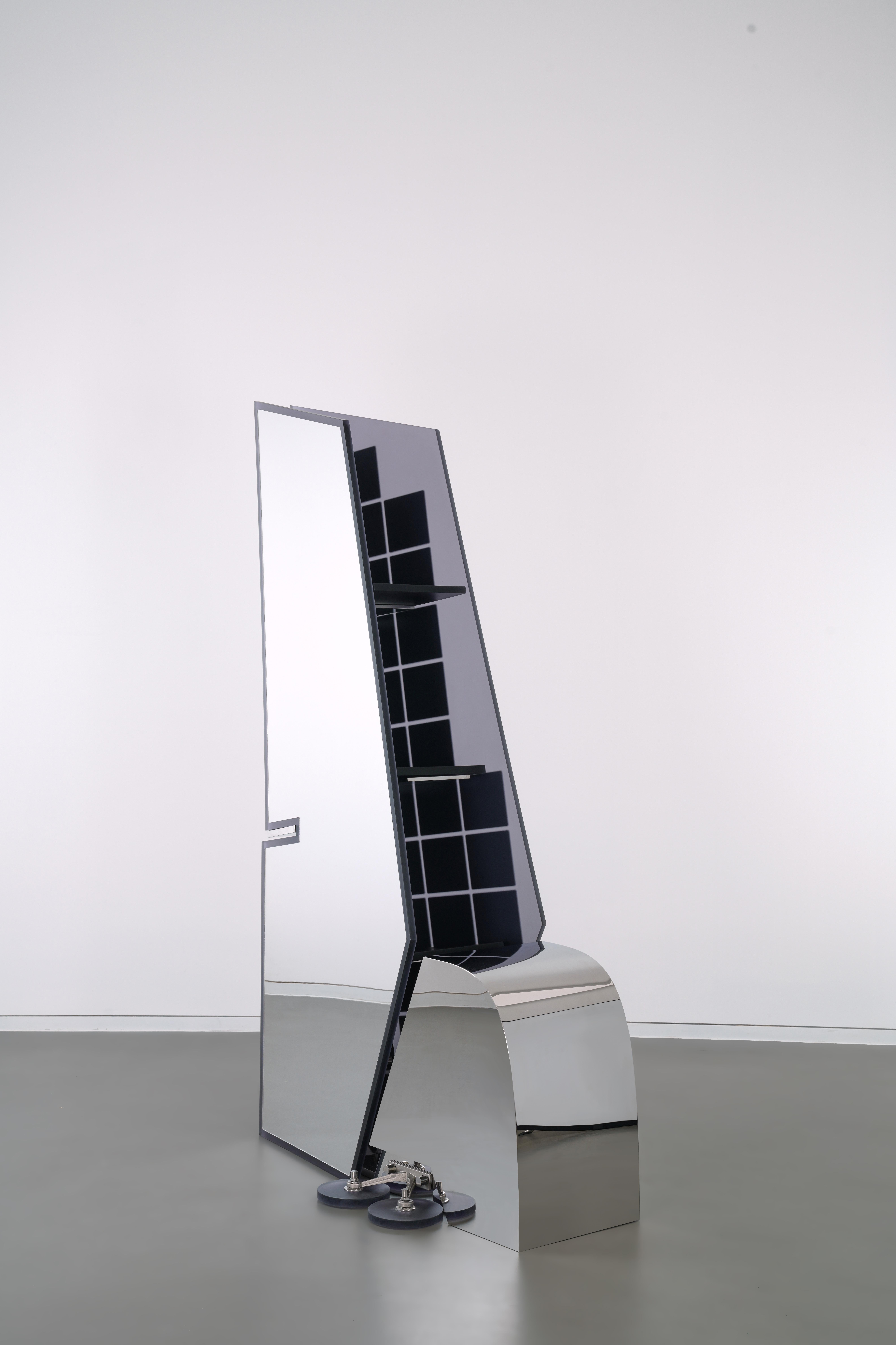 Reality Reflection features an abstract representation of the tail fin of an airplane, with a small square mirror in the form of a heat shield on one side and a full mirror on the other. The thermal insulation tiles were invented to protect the