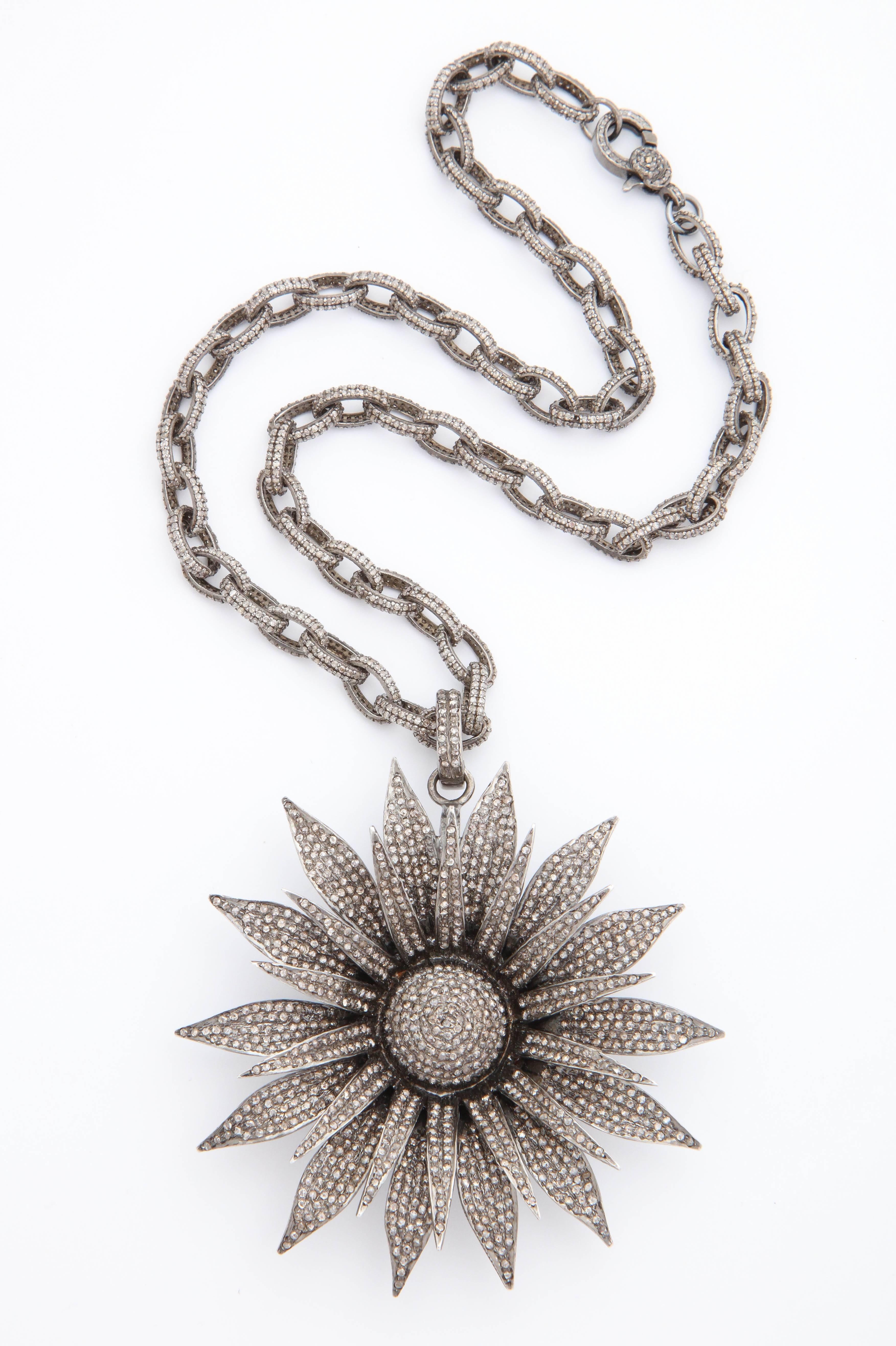 A necklace composed of a rhodium plated sterling silver chain set with approximately 5.65cys of diamonds and a rhodium plated sterling silver and diamond daisy pendant set with approximately 10.50cts of diamonds.
Length of chain: 16.00 inches
Width