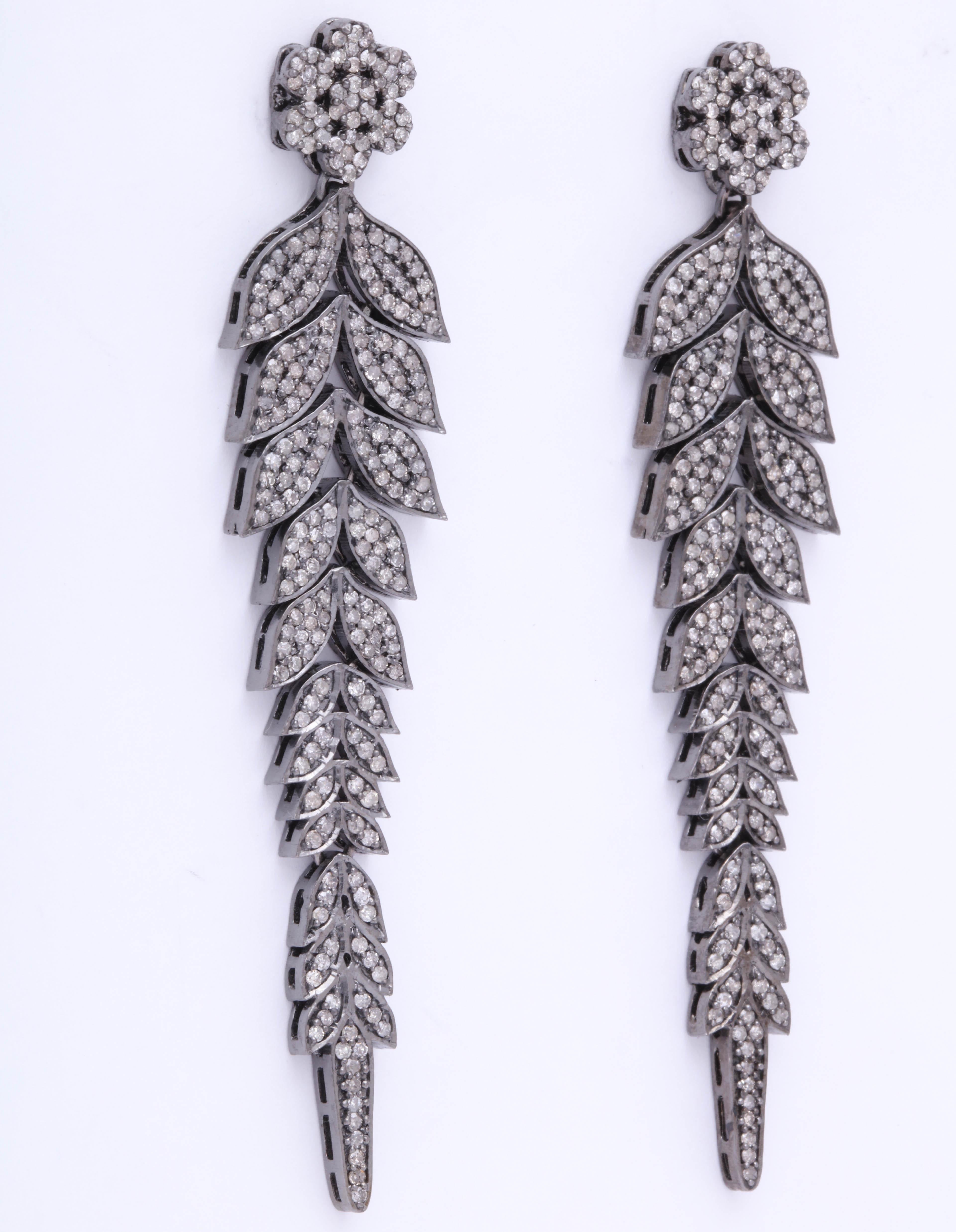 A pair of earrings composed of cascading rhodium plated sterling silver leaves set with diamonds.
The vines are suspended from rhodium plated sterling silver and diamond flower studs.
There are approximately 2.90 cts of diamonds.

Length: 3.00 inches