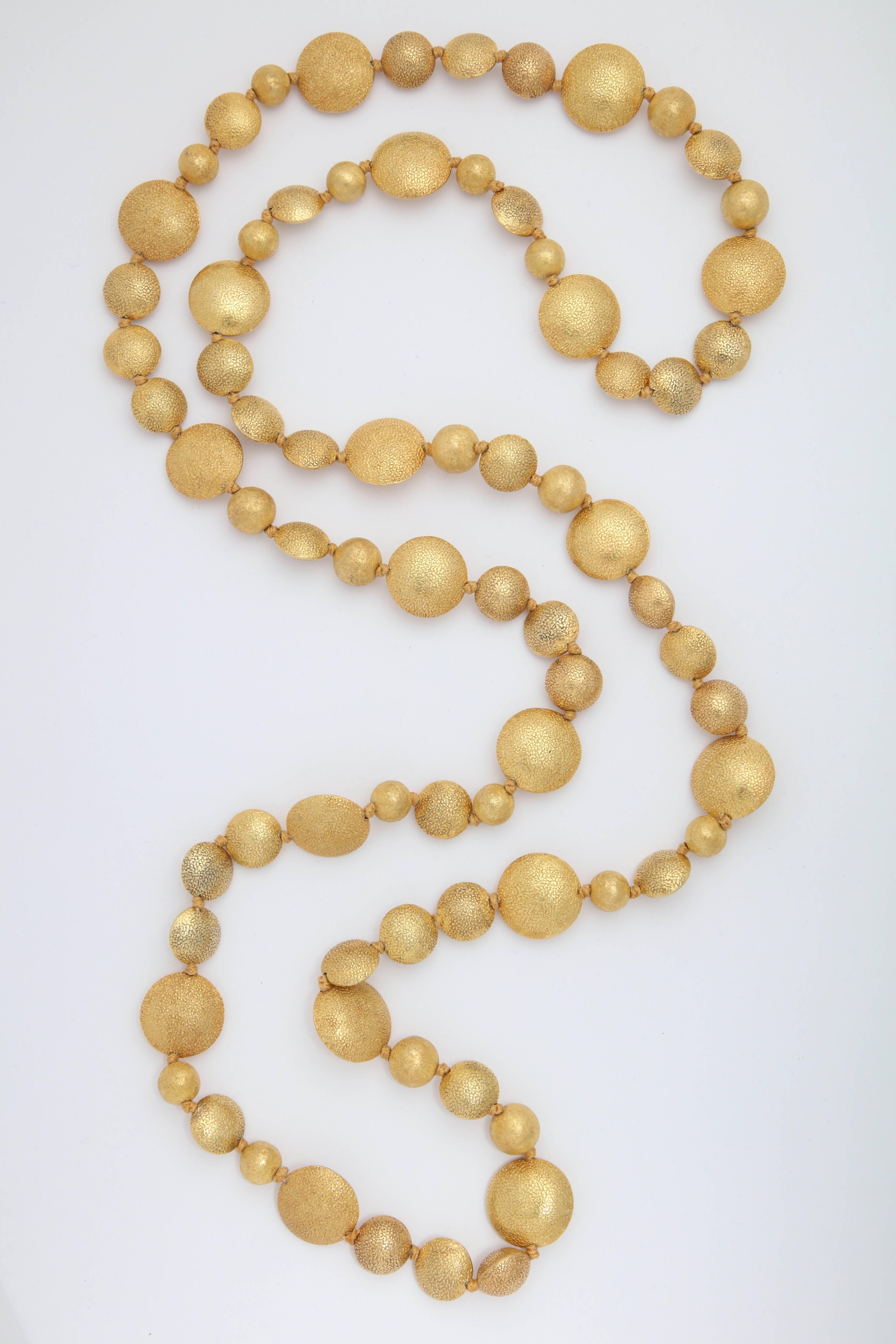 An 18kt yellow gold Smartie Pants necklace composed of 2 sizes of textured smartie gold beads and 2 sizes of textured gold sphere beads. There are 76 beads in total.
Length: 50.00 inches
Large smartie bead: .90 inch
Small smartie bead: .55 inch