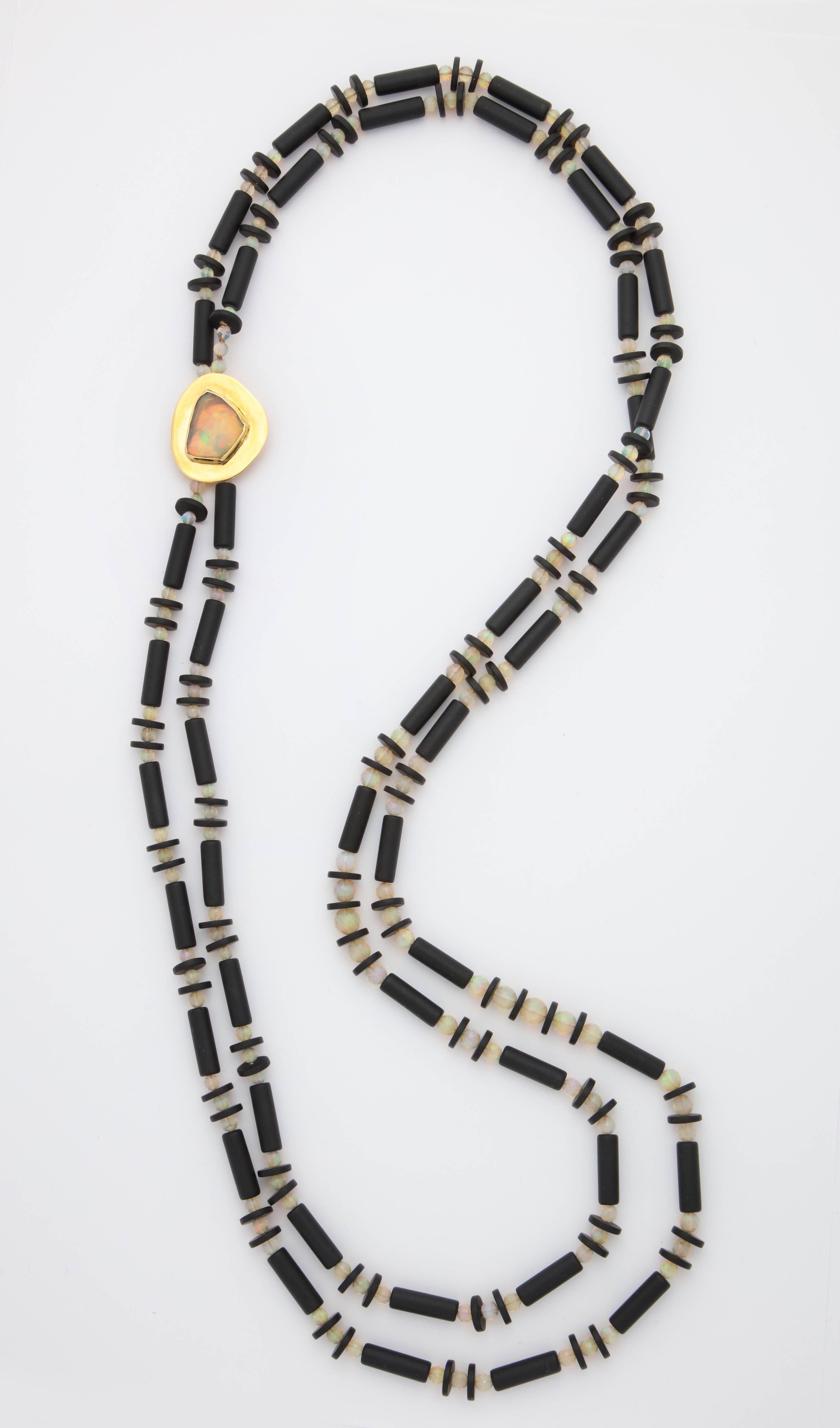A double strand necklace composed of Ethiopian opal beads and honed onyx tube and disc beads.
The 18kt yellow gold clasp houses a bezel set free form Ethiopian opal.

Length: 39.00 inches
Clasp: 1.25 x 1.50 inches