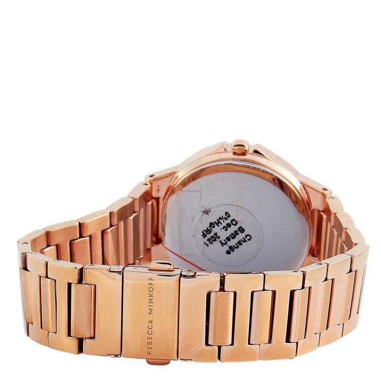 This is the Rebecca Minkoff Cali watch, reference number 2200305. It is presented with a rose gold ion-plated stainless steel case that is mounted onto a matching rose gold-tone stainless steel bracelet. The case measures 34 mm in diameter and is