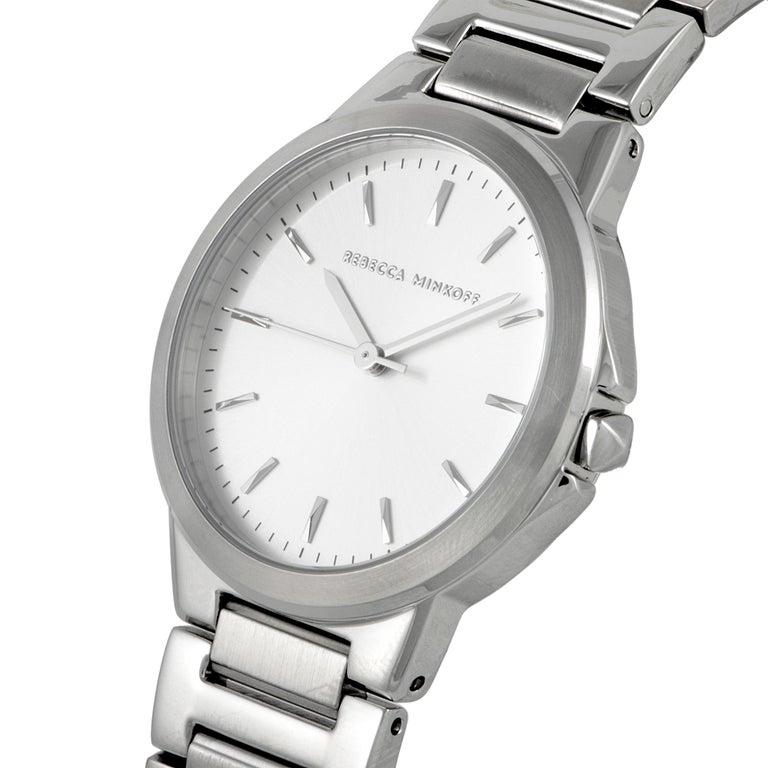 This is the Rebecca Minkoff Cali watch, reference number 2200303. It is presented with a stainless steel case that is mounted onto a matching stainless steel bracelet. The case measures 34 mm in diameter and is water-resistant to 30 meters. The
