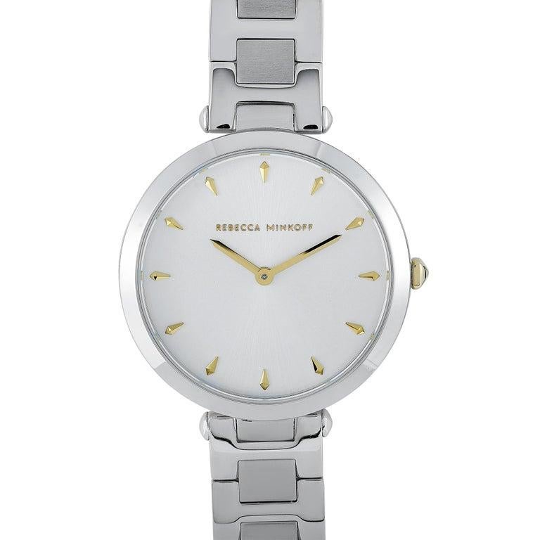 This is the Rebecca Minkoff Nina watch, reference number 2200276. It boasts a 33 mm silver-tone stainless steel case that is water-resistant to 30 meters. The case is presented on a matching silver-tone stainless steel bracelet. This model is