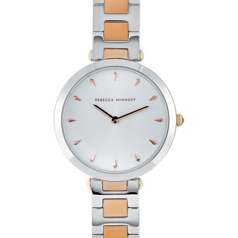 This is the Rebecca Minkoff Nina watch, reference number 2200279. It boasts a 33 mm stainless steel case that is water-resistant to 30 meters. The case is presented on a silver/rose gold-tone stainless steel bracelet. This model is equipped with a