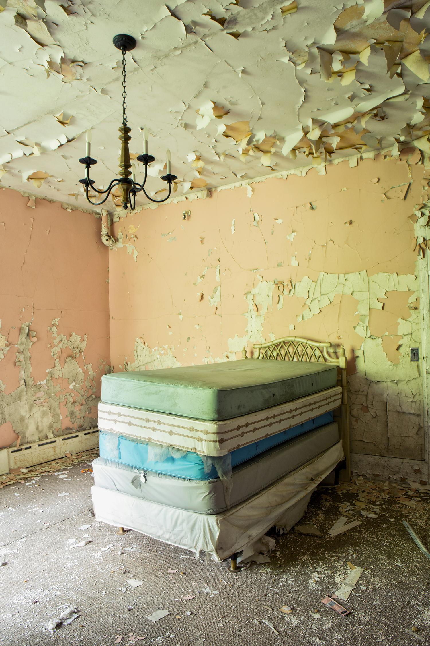 "Dream", interior, abandoned, bed, mattresses, peeling paint, peach, photography - Photograph by Rebecca Skinner