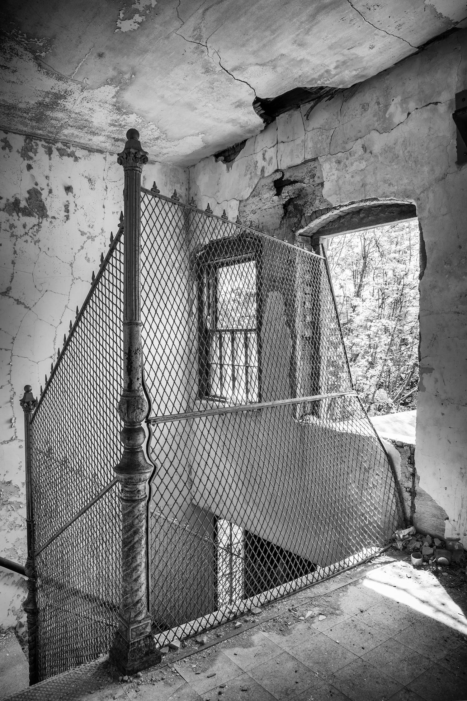 Rebecca Skinner Black and White Photograph - "Escape", contemporary, abandoned, black, white, fence, interior, photograph