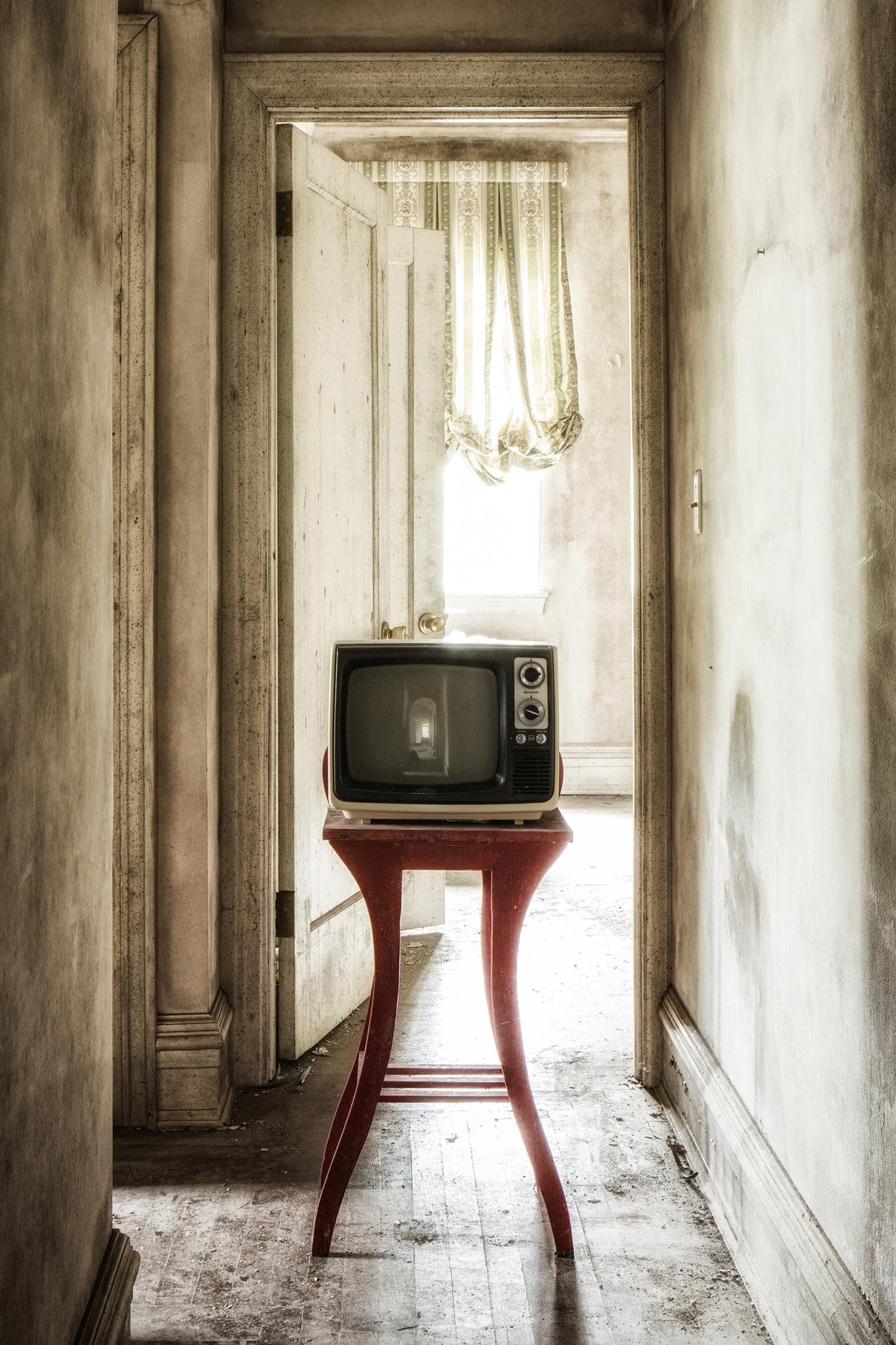 « Showtime #2 », abandonné, télévision, couloir, beige, rouge, photographie couleur - Photograph de Rebecca Skinner