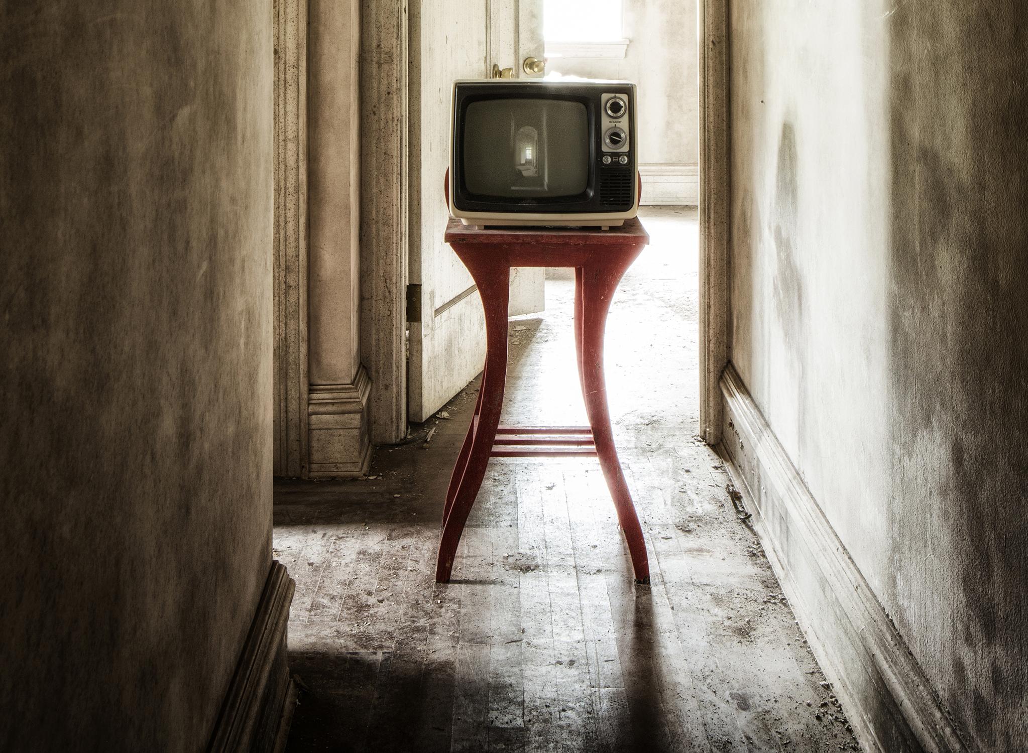 « Showtime #2 », abandonné, télévision, couloir, beige, rouge, photographie couleur - Noir Color Photograph par Rebecca Skinner