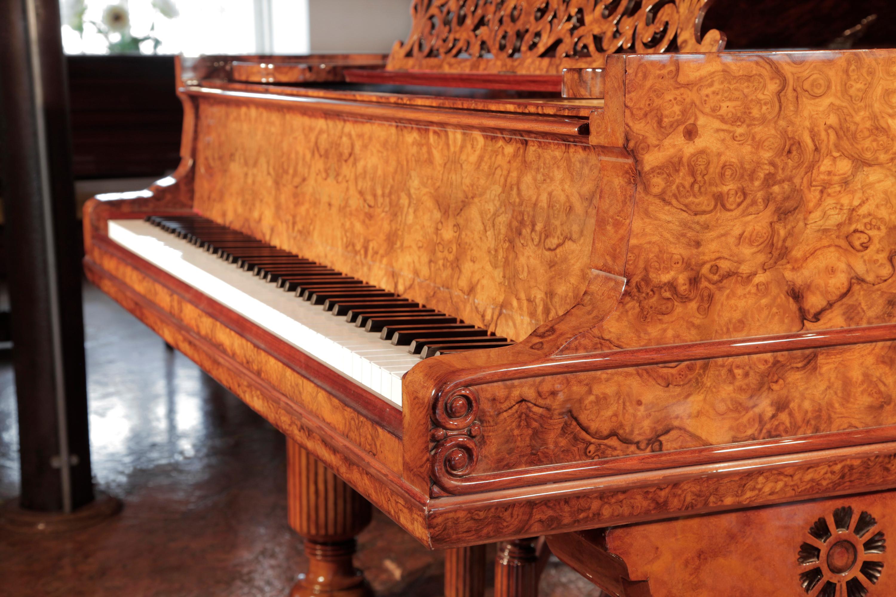 Rebuilt, 1881, Steinway & Sons Model D concert grand piano with a burr walnut case, filigree music desk and fluted, barrel legs. The music desk is an arabesque cut-out design with a central lyre motif. The piano legs are fluted, barrels with a