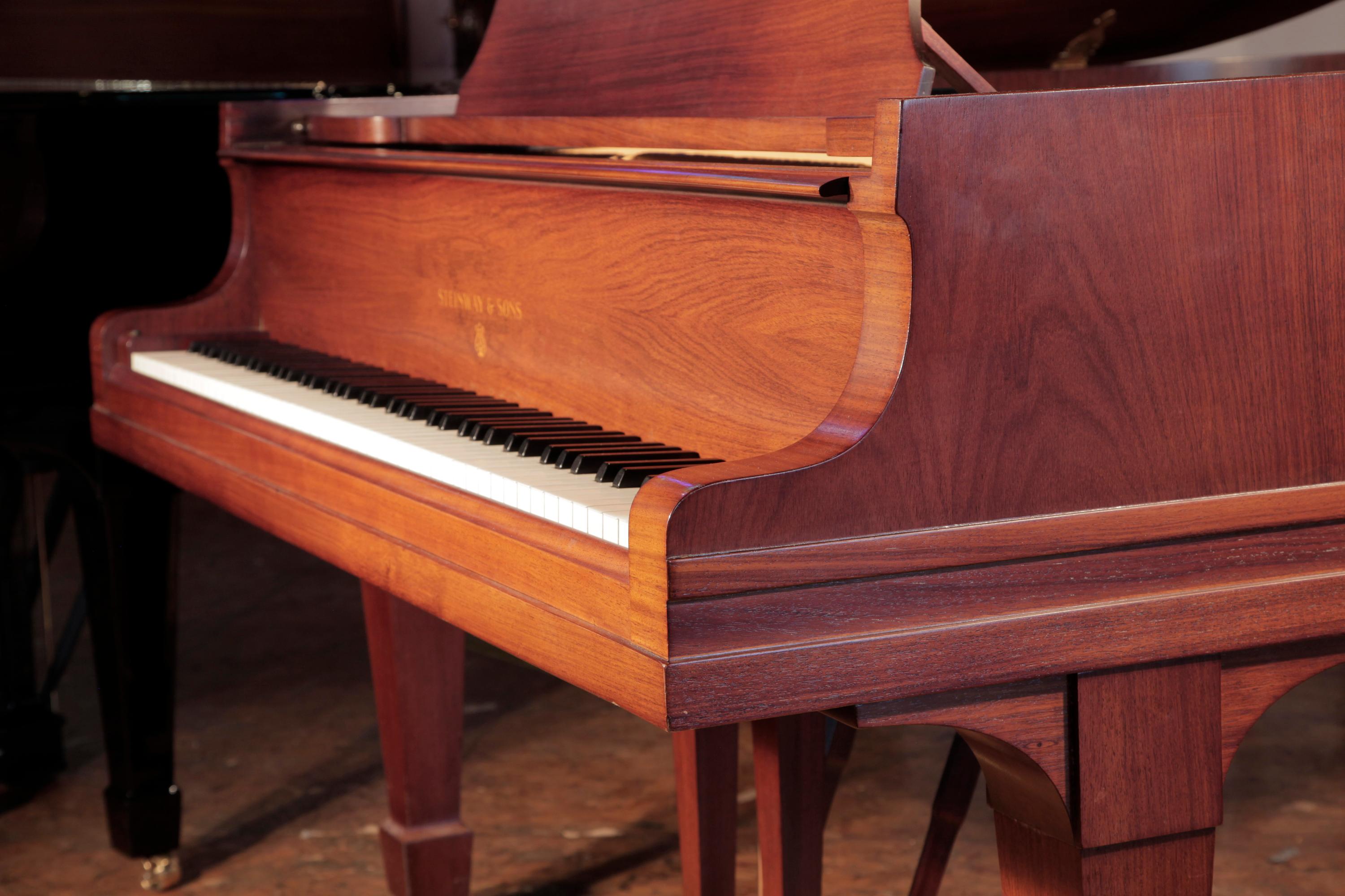 
Rebuilt, 1925, Steinway Model O grand piano for sale with a polished, walnut case and spade legs. Piano has an eighty-eight note keyboard and a two-pedal lyre
The Steinway logo is inlaid in wood on the piano fall. The piano lyre features two square