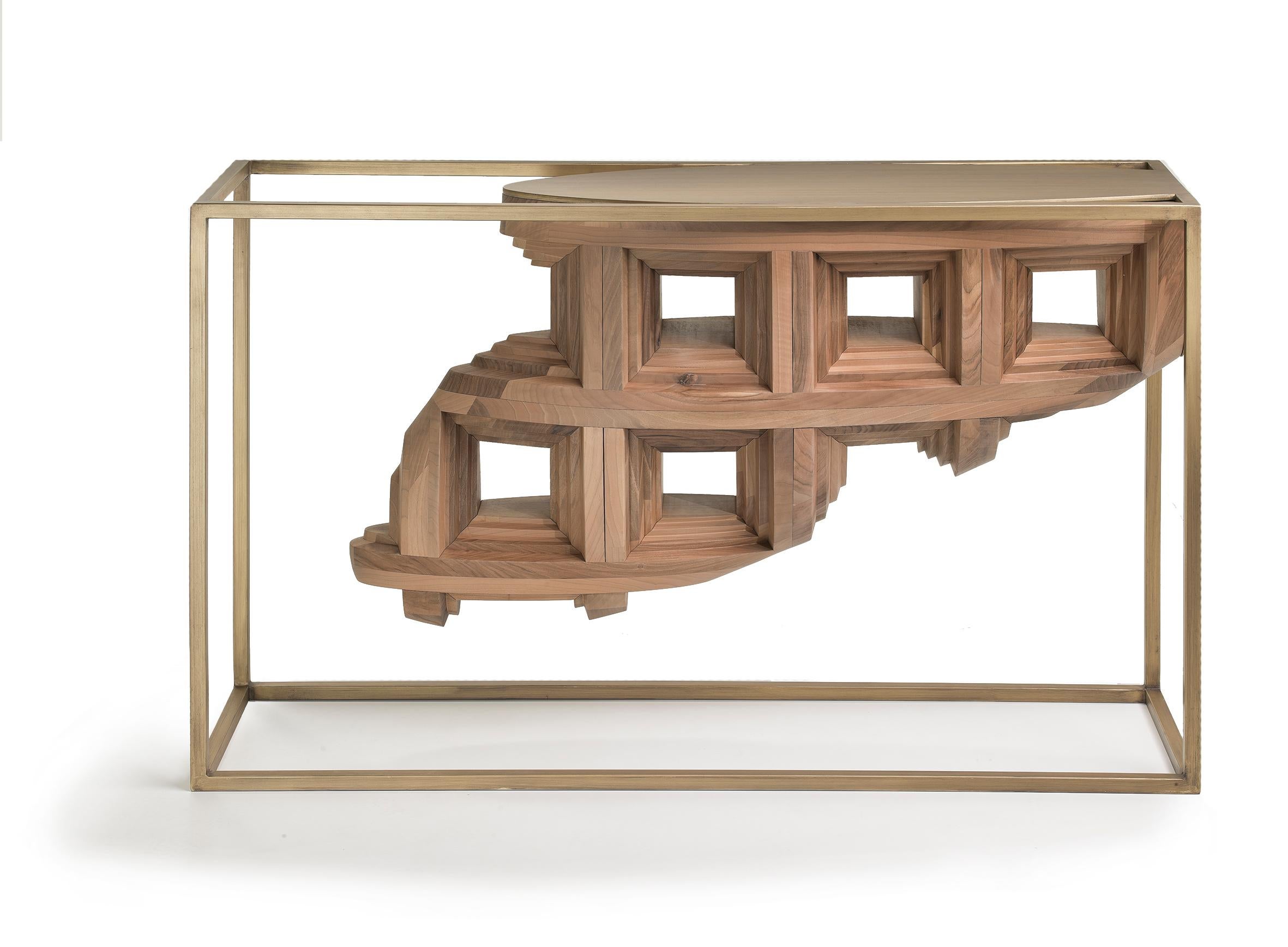 The supporting bronzed metal frame of the Rebus console is a testament to geometric elegance—a rectangular parallelogram that cradles within it a wooden asymmetrical, organically shaped fragment. It's as if a museum display case has come to life,