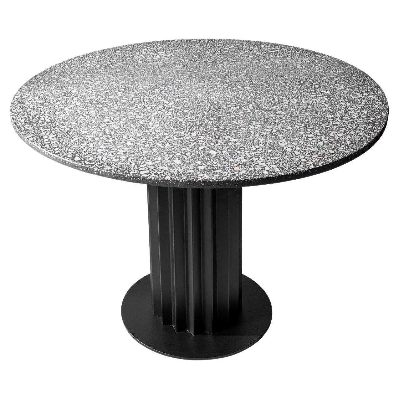 Table de salle à manger ronde réinterprétée en métal noir et terrazzo