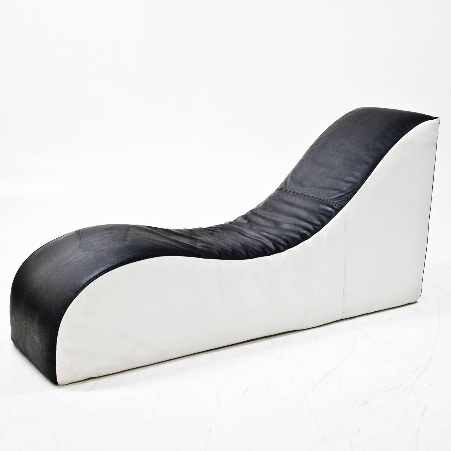 Large recamiere with a black-and-white leather upholstery and small seat. The recamiere is in the shape of an S and contrary to the small seat white on the sides and black on the reclining surface. The leather is in a good, used