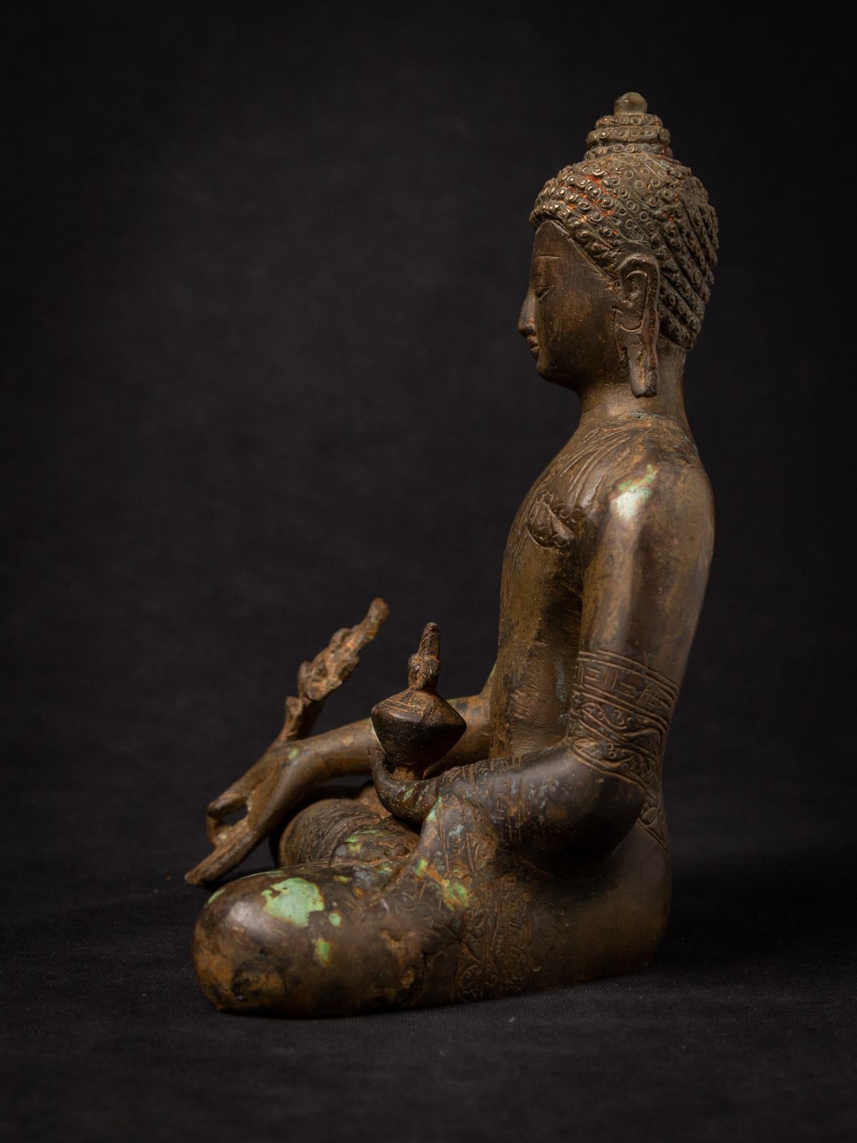 This Bronze Nepali Medicine Buddha statue is a true masterpiece of craftsmanship and spirituality. Standing at a majestic 21,8 cm in height, with dimensions of 16,8 cm in width and 13,1 cm in depth, it is a substantial representation of the Medicine