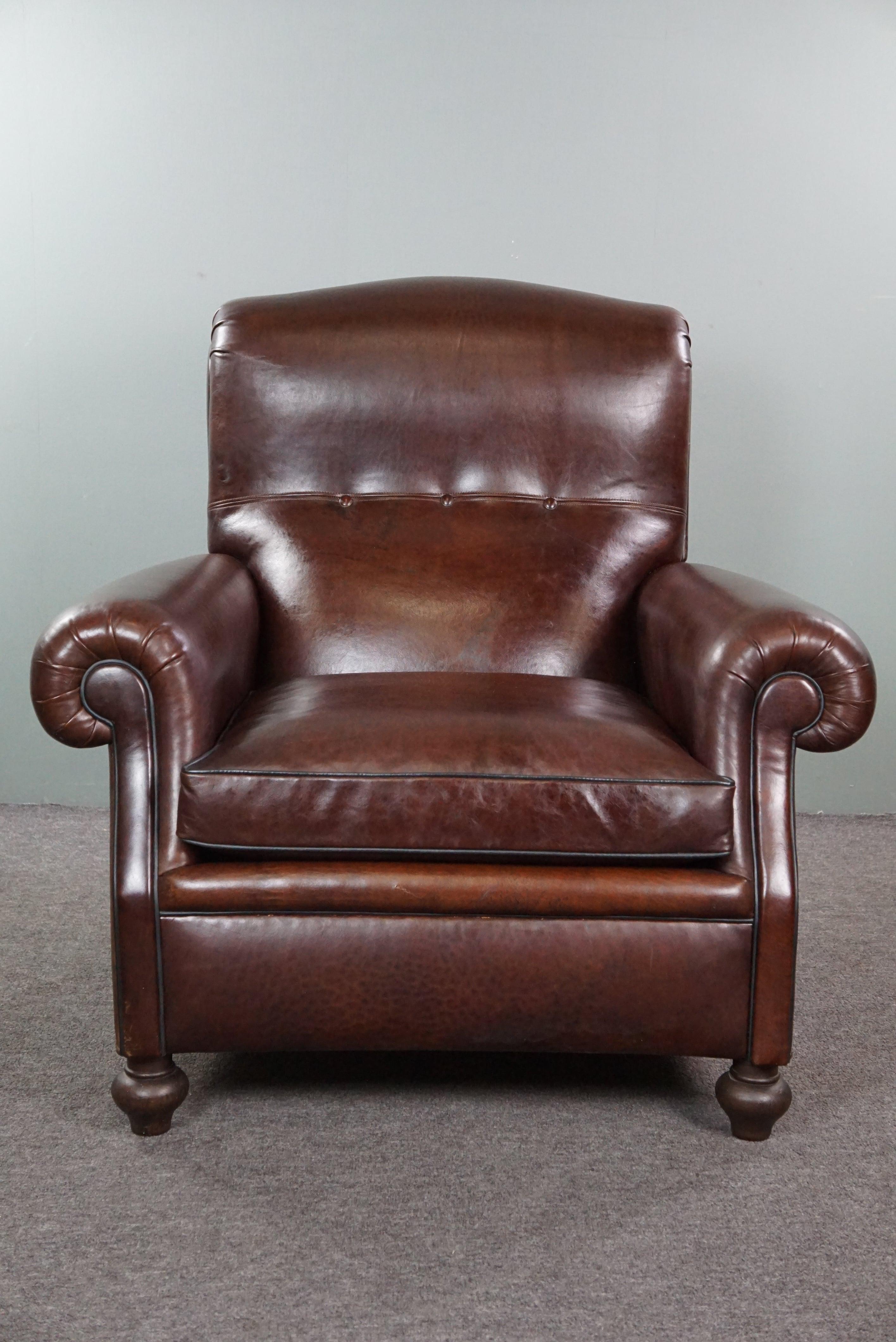 Offered is this beautiful old English armchair that has been recently reupholstered with lovely dark-colored sheep leather. For those seeking a stunning and comfortable English armchair to elevate any room of their choice to an even higher level,