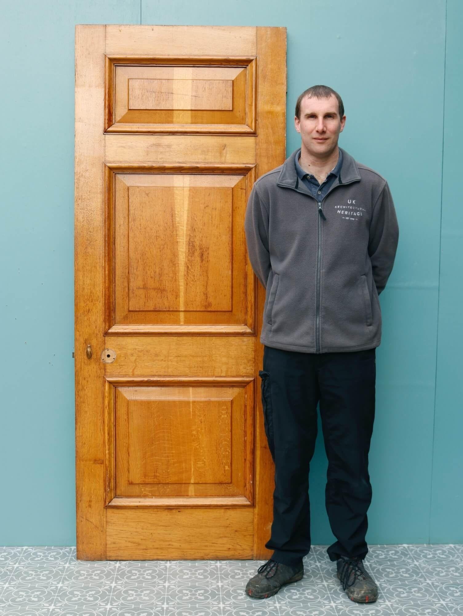 A strong and substantial reclaimed 1920s oak door suitable for interior or exterior use. This sturdy antique oak door includes an original frame and architrave for both sides (pictured), all smartly finished with varnish that enhances the beautiful