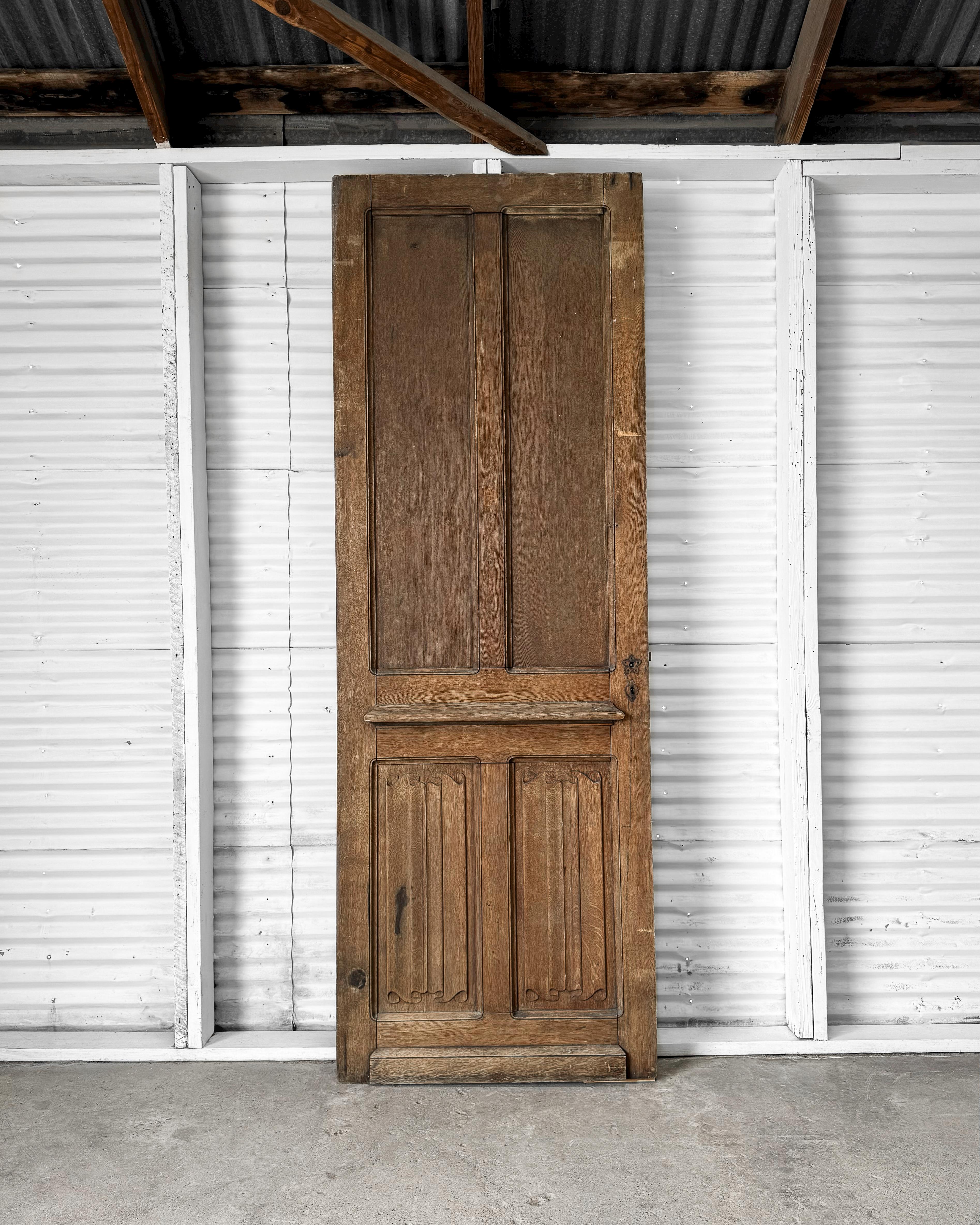 Lleva el encanto histórico a tu casa con esta puerta francesa recuperada del siglo XIX. Fabricada en madera de nogal, la puerta presenta un diseño de cuatro paneles, un elegante ribete biselado curvado en los paneles superiores y detalles tallados
