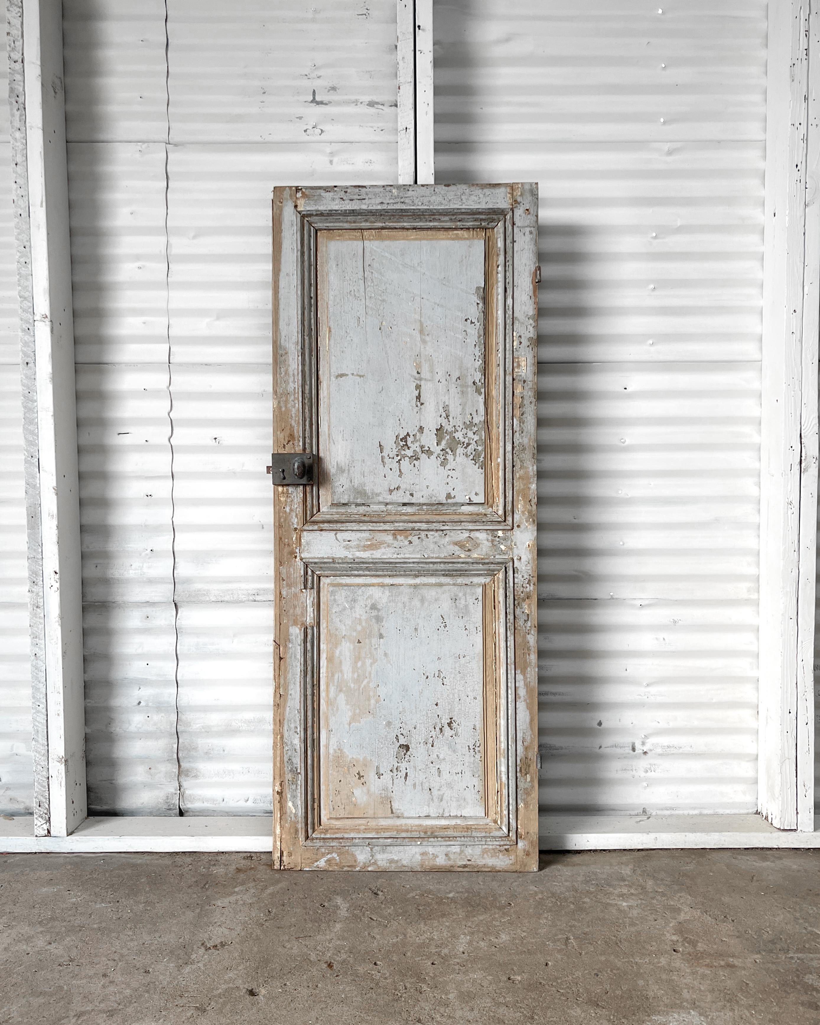 Once enclosing a storage space, this old 2-panel door was reclaimed from a home in the French countryside. Featuring raised panels with grooved and beveled trim detailing, the lovely weathered “French blue” paint will infuse your home with