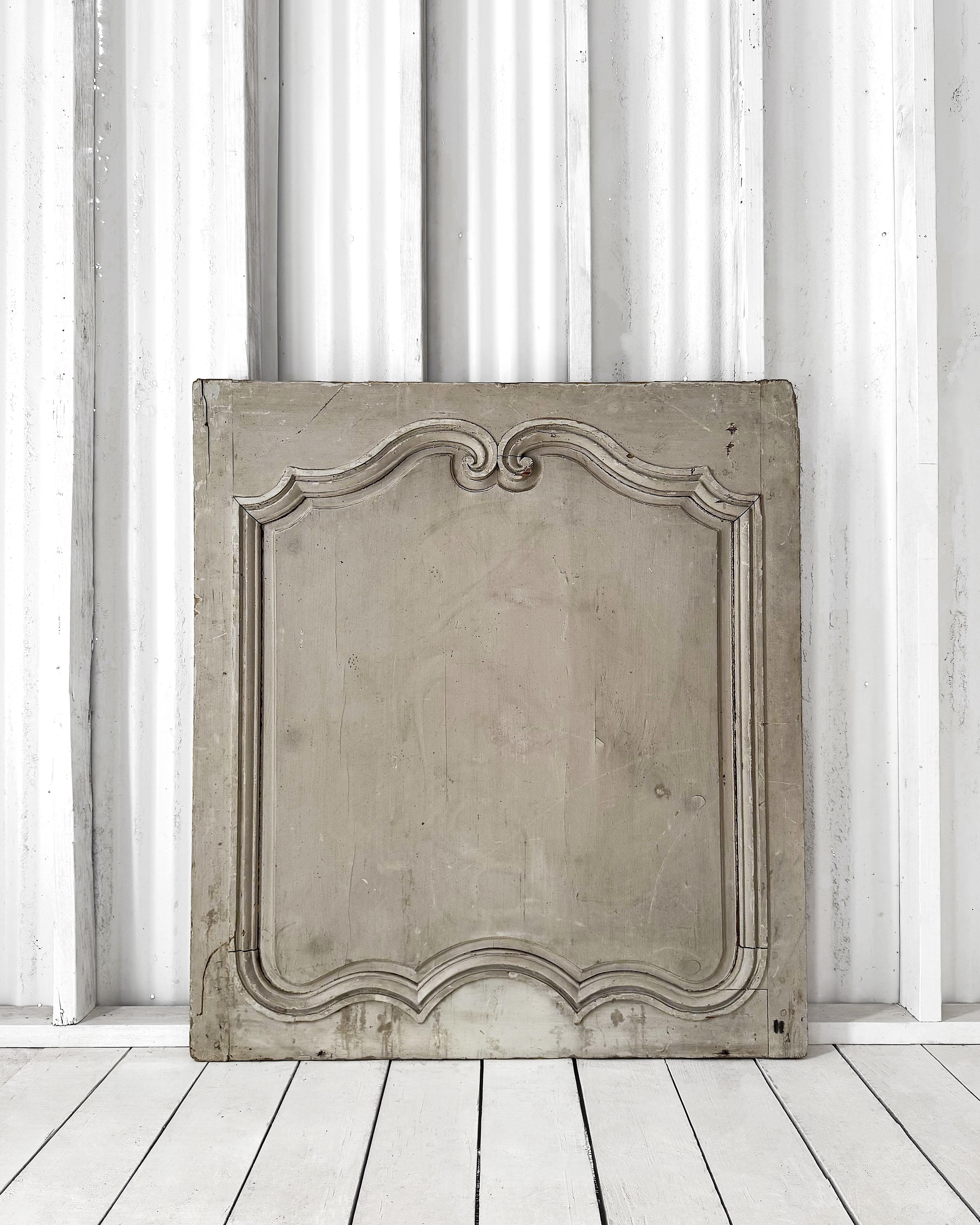 Llamativo panel de boiserie francés de mediados del siglo XIX con pintura original verde oliva pálido, delicadamente desgastada con el tiempo para revelar sutiles matices subyacentes. 

El marco tallado presenta elegantes volutas en la parte