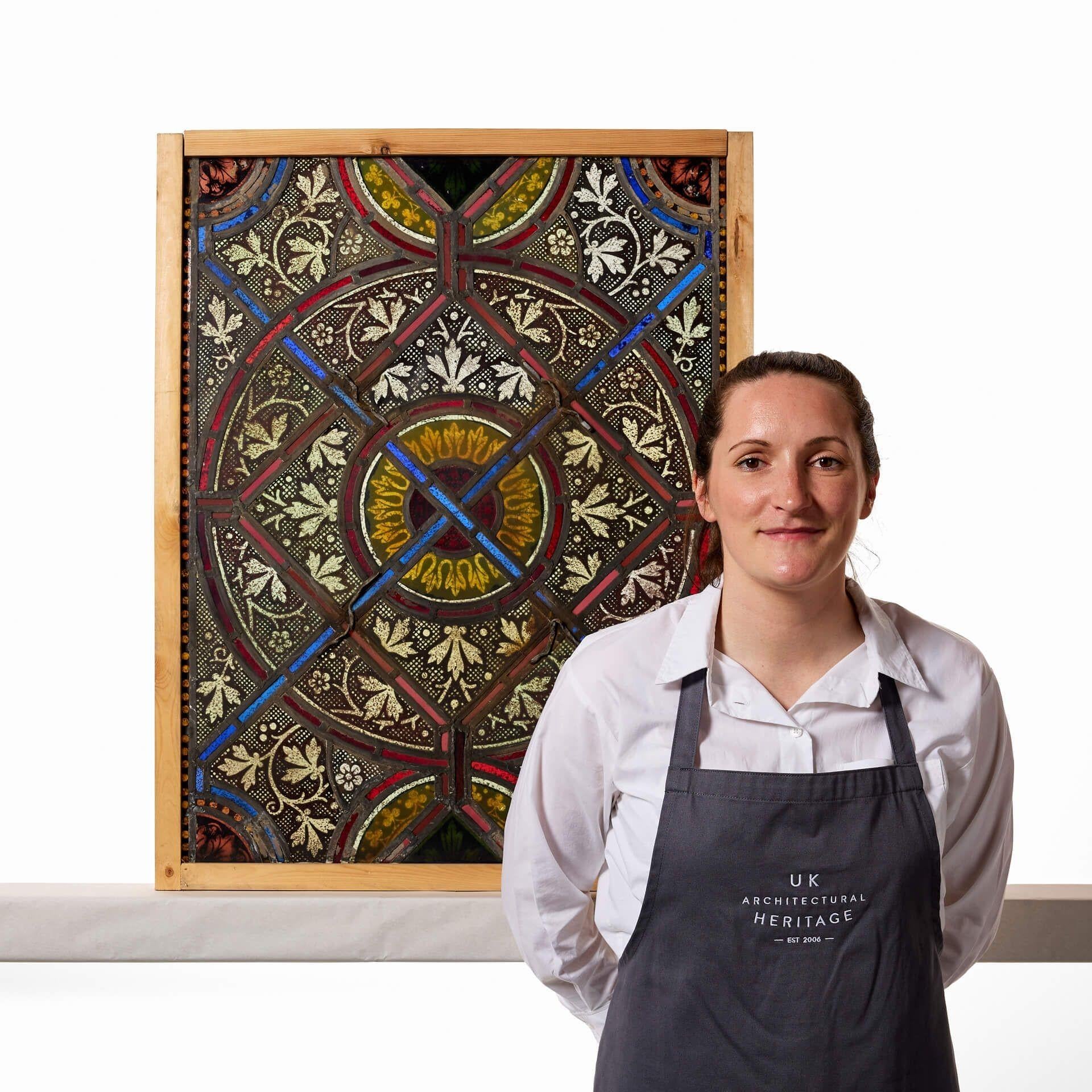 A colourful and beautifully detailed reclaimed late 19th century English stained glass window, one of four similar we are selling. This stunning window pairs intricate foliage patterns with red, blue, orange and yellow panes of stained glass placed