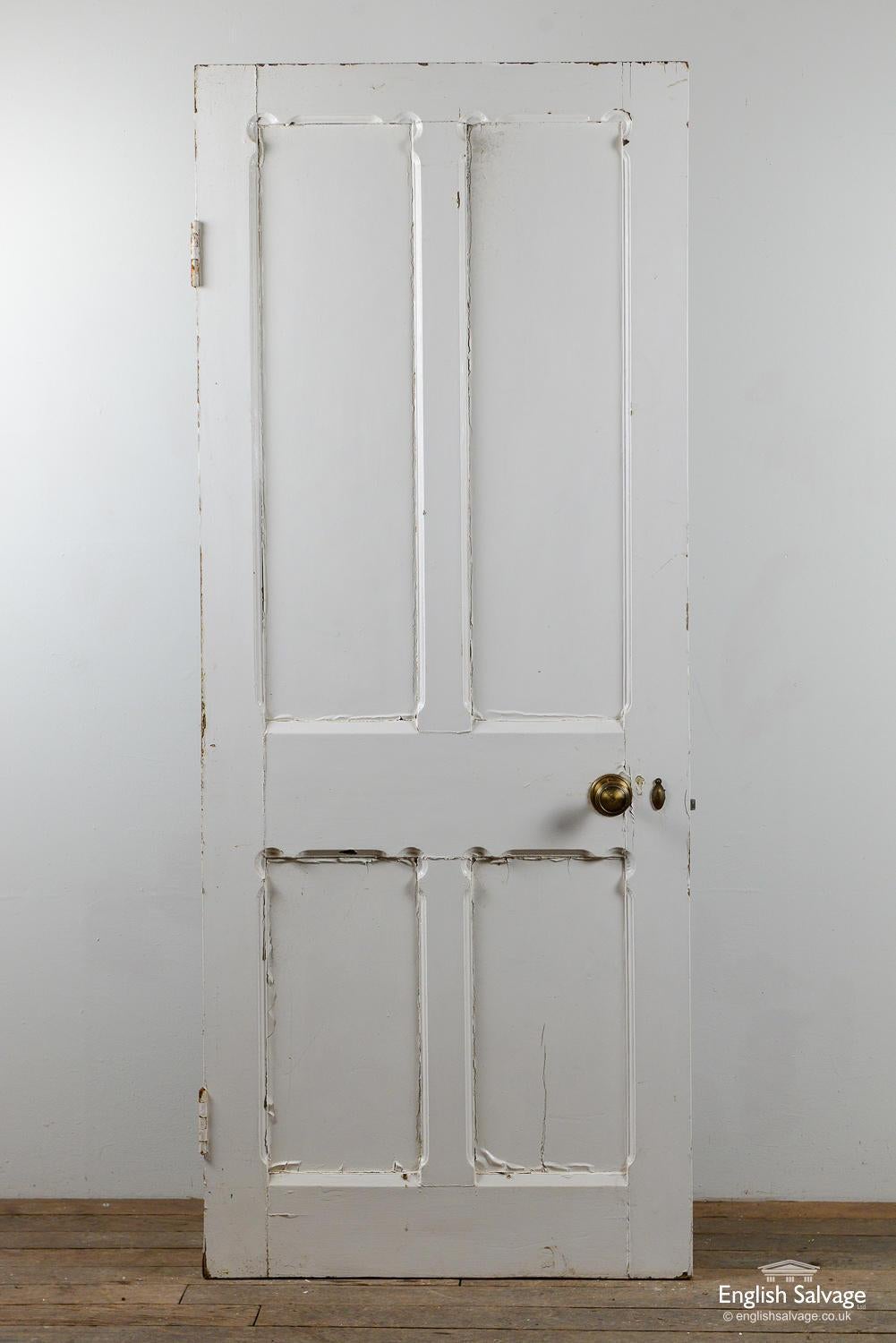 Salvaged pine door with four carved panels and two hinges. The door is similar to others in the set but without the oak veneer. Old handle, lock and nail holes present.