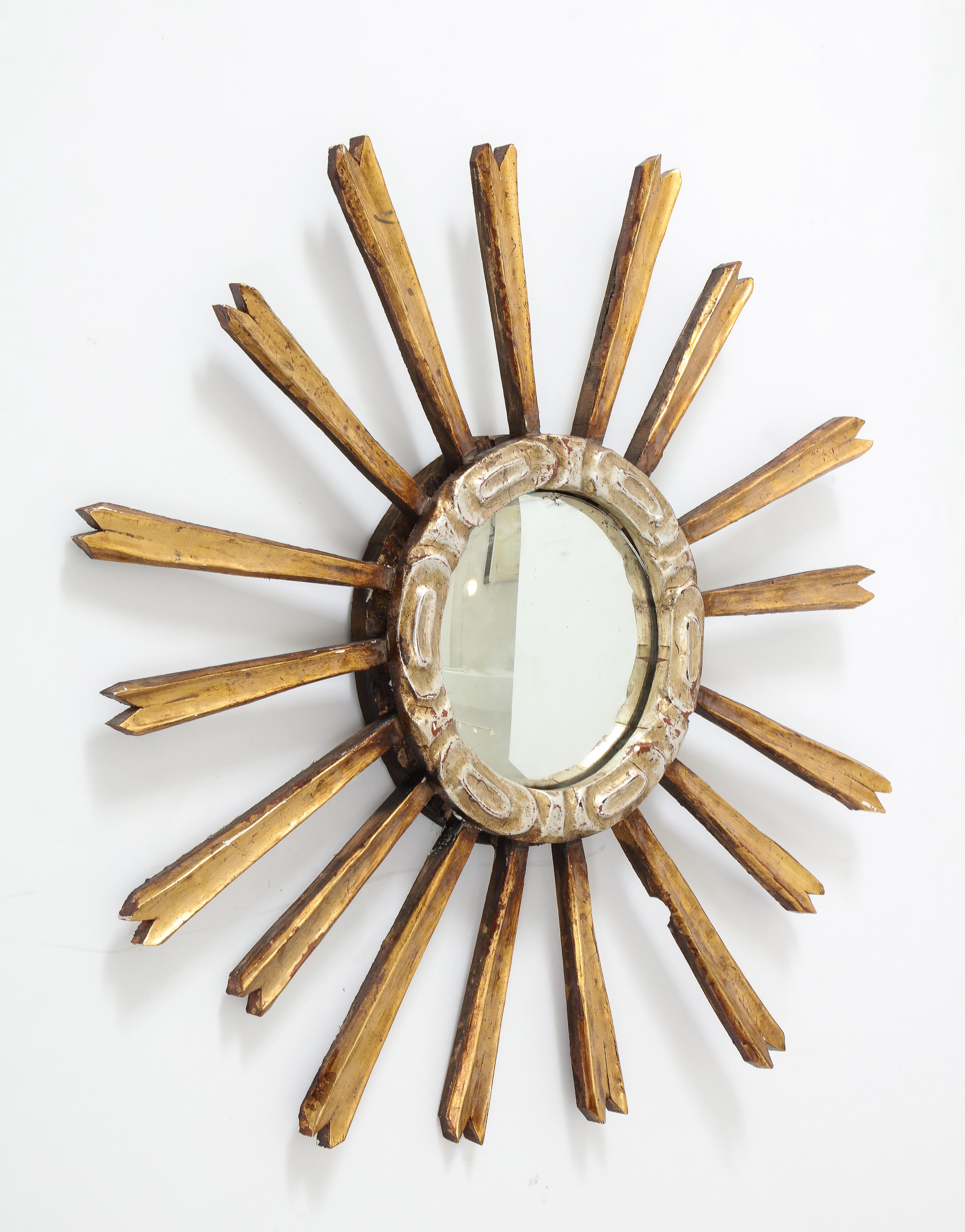 A Sunburst mirror using reclaimed silver and gold rays. The Spanish sunburst mirror is an iconic design that has held the test of time for centuries. This newly-made design uses reclaimed silver and gold carved wood elements to recreate a modern