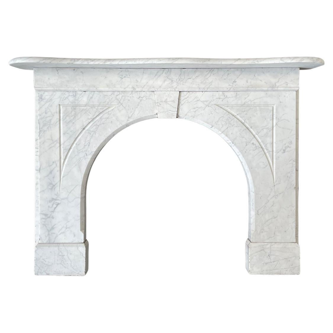 An arched Victorian Carrara marble fireplace surround of good proportions. The plain frieze sits below a serpentine mantle with a bullnose edge and above a plain keystone and flutes to the arched spandrels. Circa 1860.

For detailed sizes please see