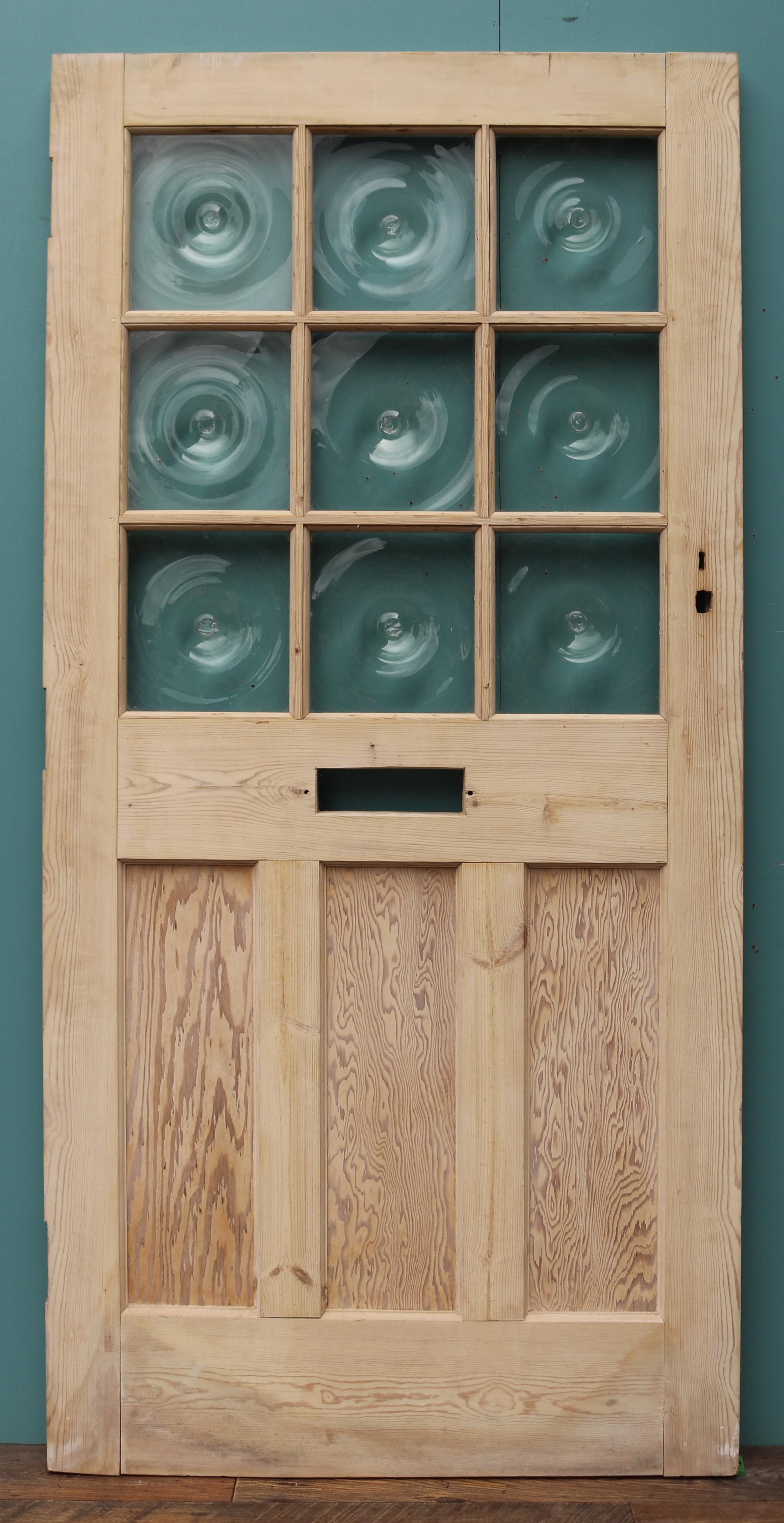 A reclaimed pine front door fitted with nine panels of bullseye glass.