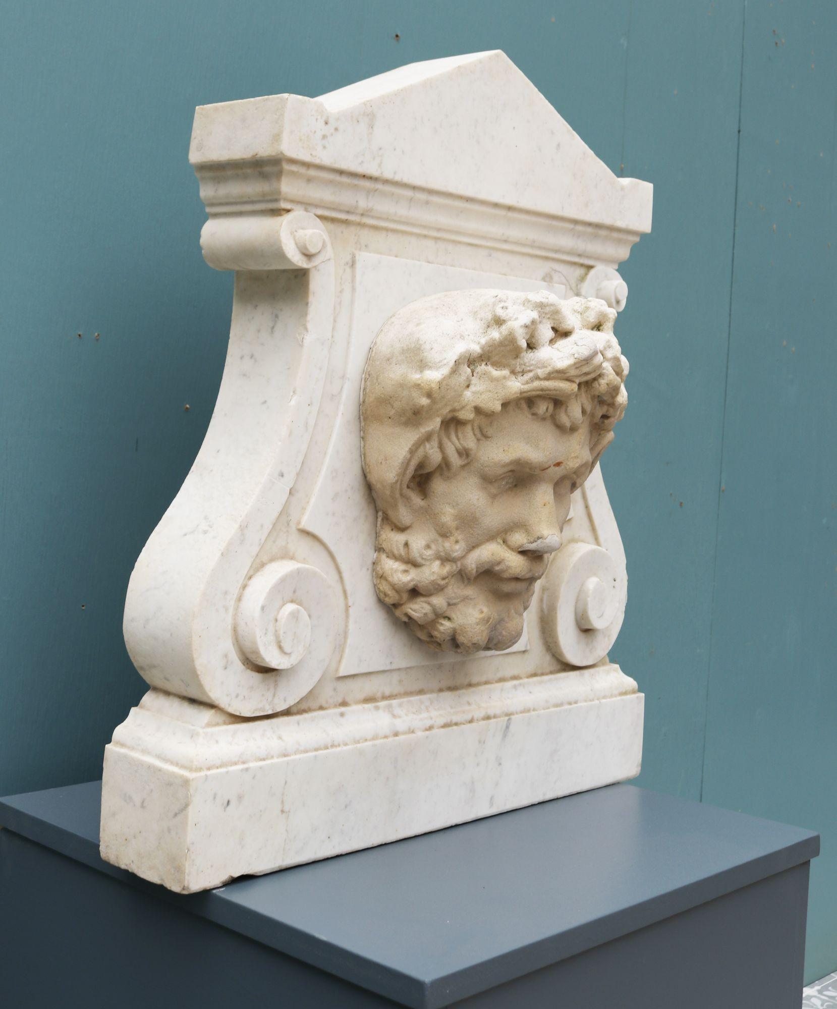 Reclaimed Carrara Marble Garden Plaque / Wall Fountain. An early 20th century, Italian marble plaque with decorative scrolling with an applied composition stone head in the centre. This could be drilled to make a wall fountain.