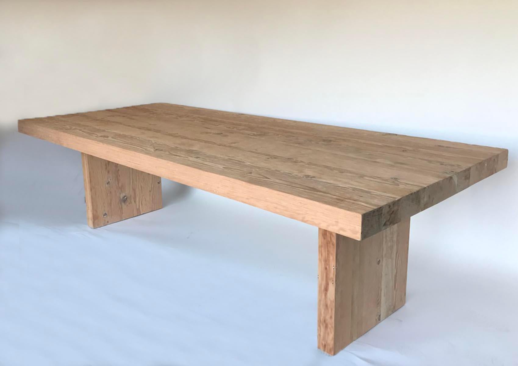 Reclaimed Douglas Fir large table with two perpendicular bases. This table is shown in natural wood without a finish. Natural knots and cracks and some traces of paint are part of the natural reclaimed wood. 
This table can be finished in a choice