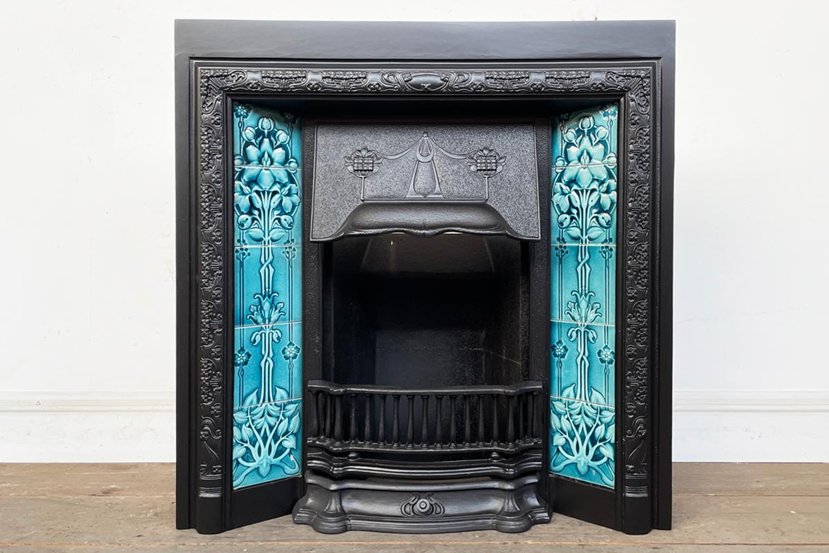 Reclaimed Edwardian cast iron and tiled fireplace grate in the Art Nouveau manner with an adjustable canopy. Complete with an original set of Art Nouveau fireplace tiles. Circa 1905.

Finished in heat-resistant black paint and supplied with a new