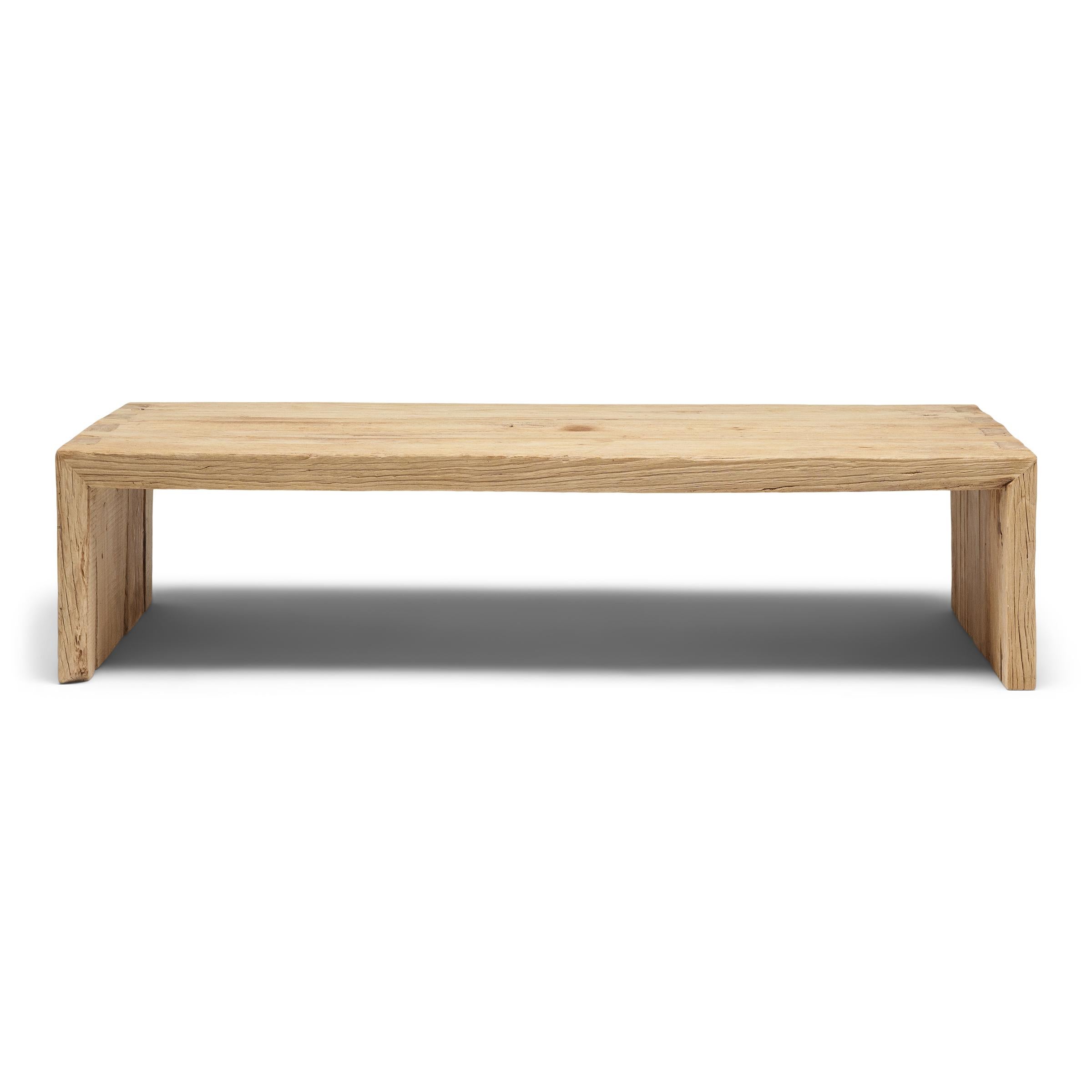 Cette table basse artisanale est une célébration du style wabi-sabi. Fabriquée en bois d'orme épais récupéré dans l'architecture de la dynastie Qing, la table présente un design minimaliste en cascade et est laissée brute pour préserver la beauté