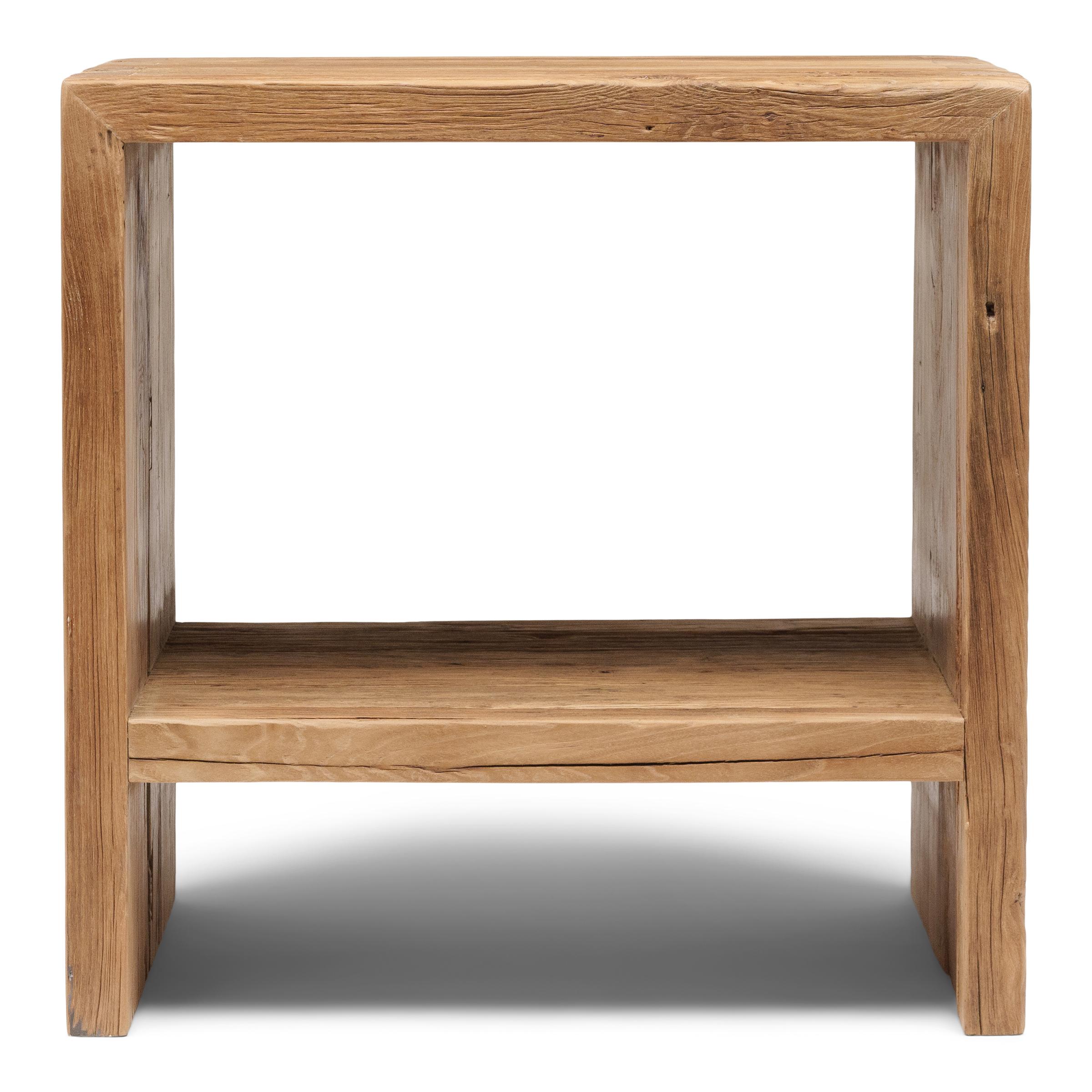 Esta mesa auxiliar artesanal es una celebración del estilo wabi-sabi. Fabricada con gruesas maderas de olmo recuperadas de la arquitectura de la dinastía Qing, la mesa tiene un diseño minimalista en cascada con lados rectos, un estante bajo y