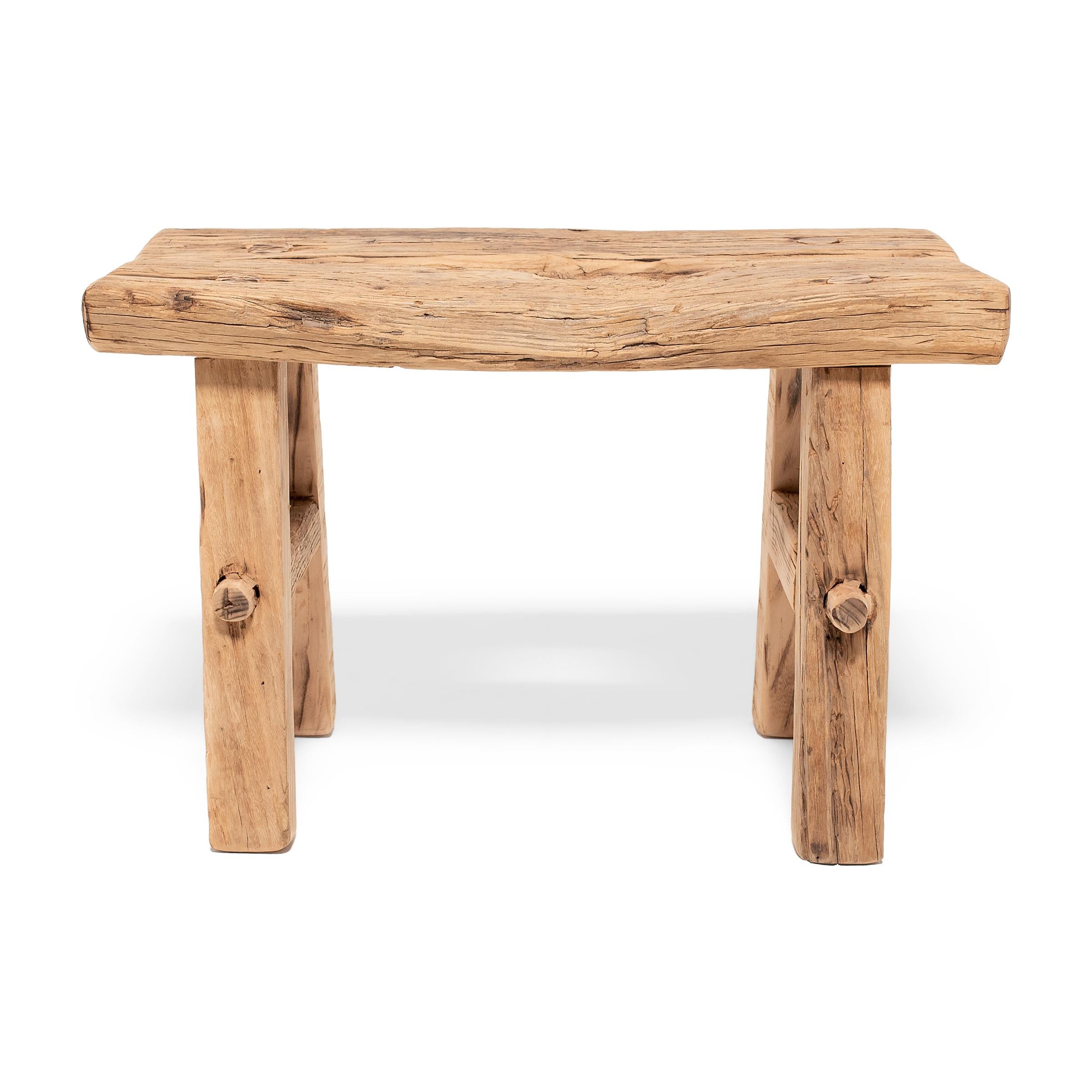 Crafted of wood reclaimed from 18th-century Chinese buildings, this contemporary splayed-leg stool is the epitome of farmhouse modern. Embracing the notion of “wabi-sabi,” the low stool charms with irregular edges and an array of knots, splits, and