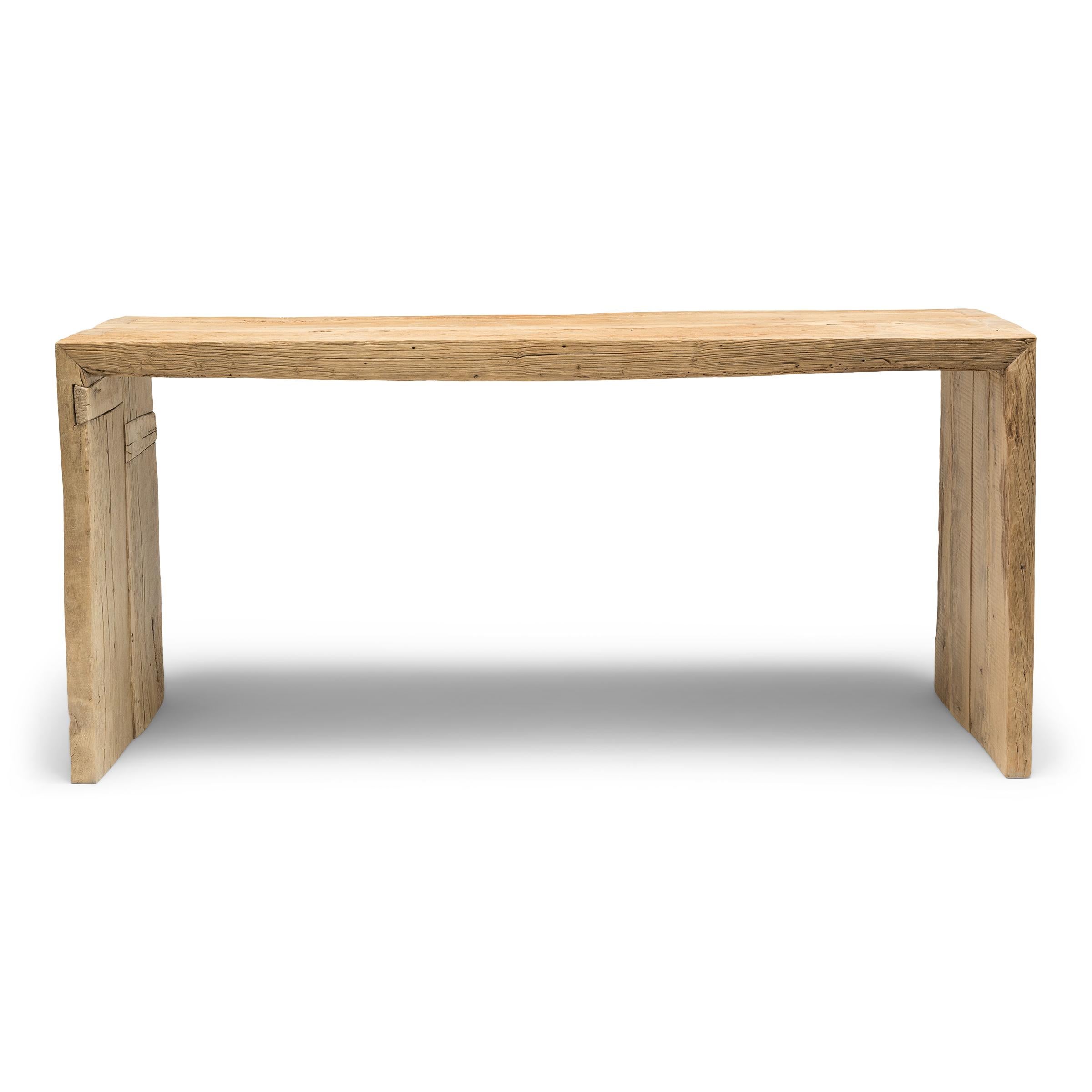 Esta consola contemporánea es una celebración del estilo wabi-sabi. Fabricada con madera recuperada de la arquitectura de la dinastía Qing, la mesa tiene un diseño minimalista en cascada con esquinas de cola de milano que recrean los métodos
