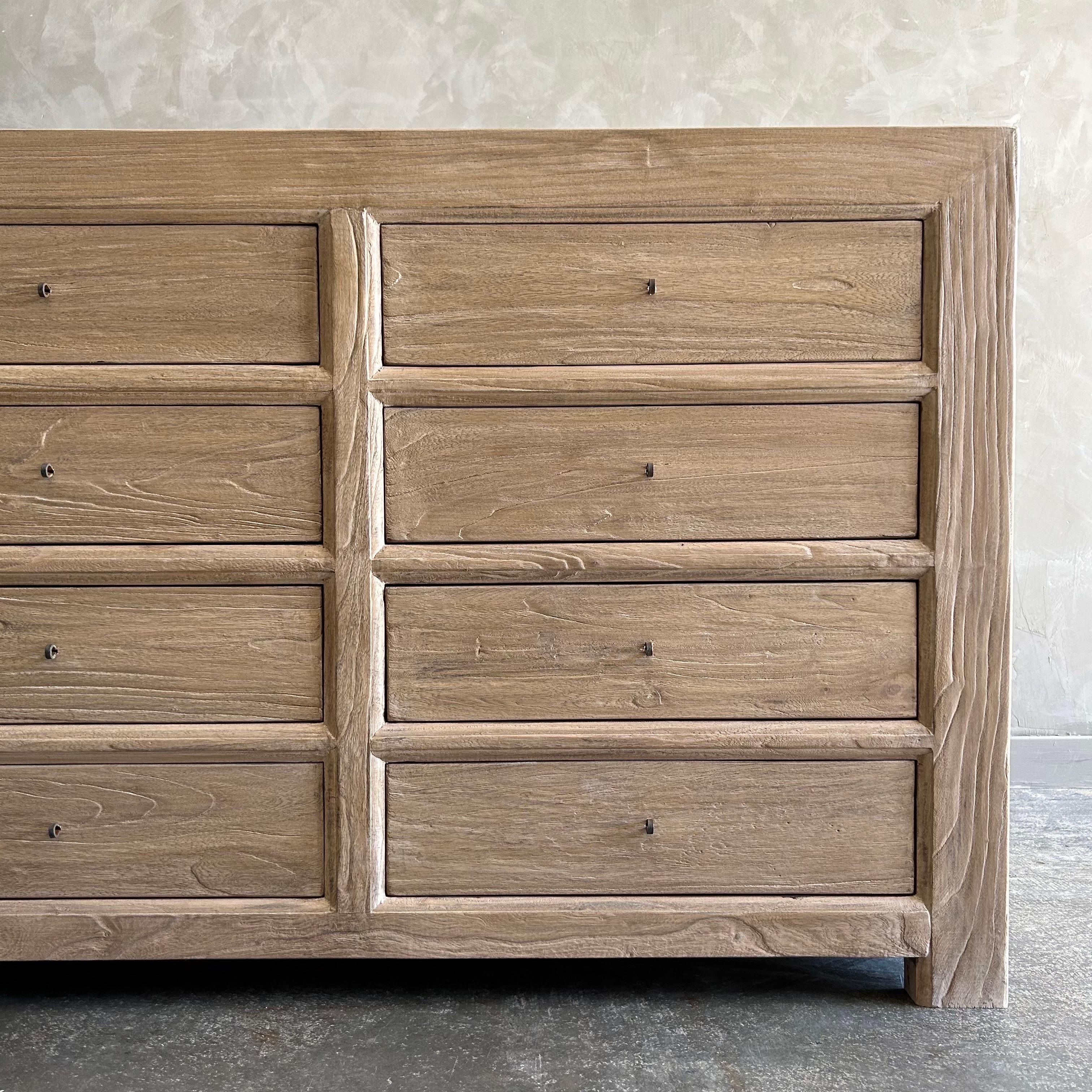 Un capolavoro classico che combina senza sforzo stile e funzionalità.  Realizzato in legno massiccio di olmo recuperato, questo comò offre una moltitudine di cassetti per soddisfare tutte le tue esigenze di stoccaggio.  Il suo stile classico