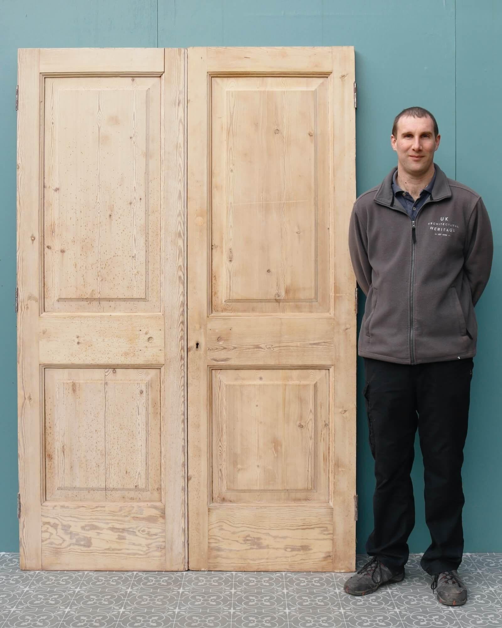 A pair of reclaimed stripped pine double doors in 2-panel Edwardian style dating from the early 20th century. These versatile antique double doors are suitable for internal or exterior use, making a beautiful set of room dividing doors or exterior