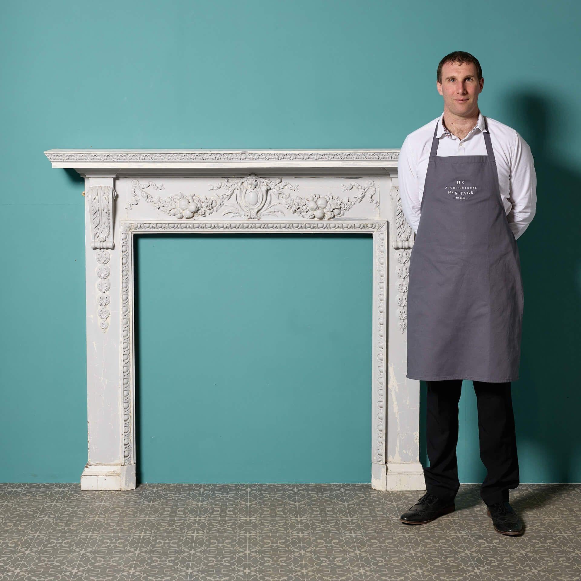 An antique Neoclassical style fireplace surround constructed from pine, with applied composition decoration, painted.

Additional dimensions:

Opening height 109.5 cm

Opening width 101.5 cm

Width between outsides of the foot blocks 148 cm.