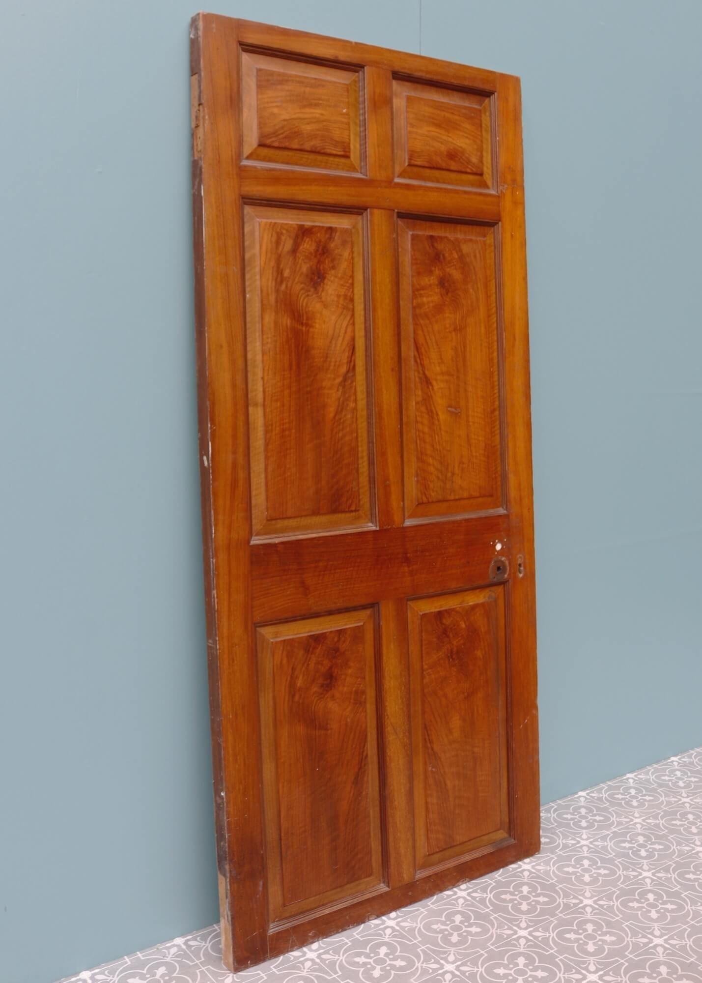 A reclaimed Georgian internal door dating from the early 19th century. Constructed from pine, this six-panel interior door is dual-coloured with differing details to the front and the back. The front is walnut veneered, displaying a handsome grain