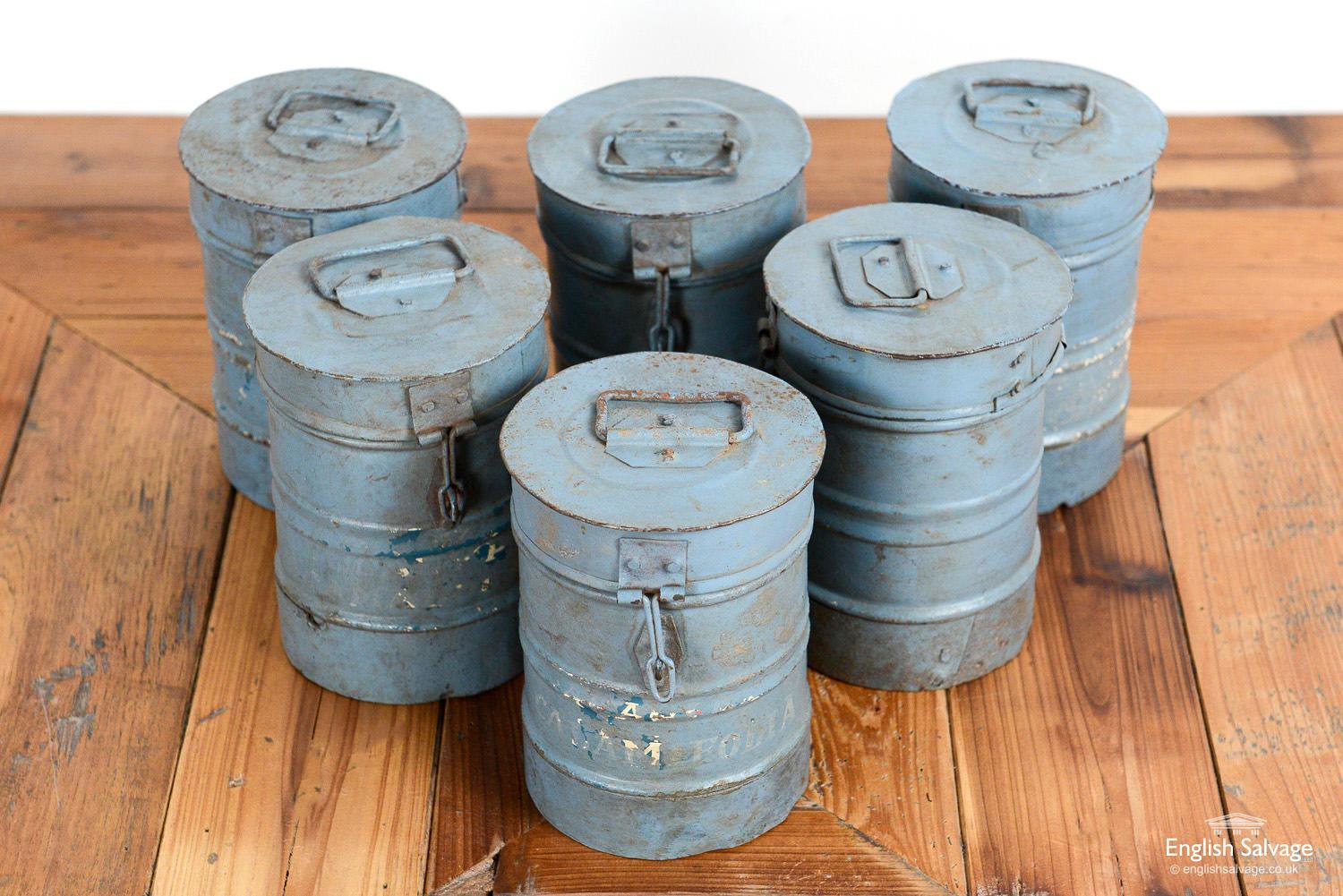 Lovely reclaimed small storage canisters with hinged lids and handles to the tops. Most are painted grey, three are unpainted. They all have an appealing industrial look, with scratches and dinks commensurate with age and use.