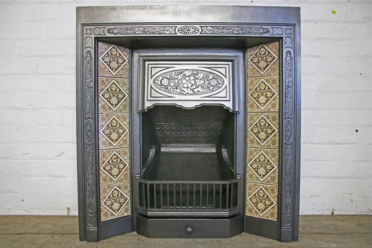 Reclaimed late Victorian cast iron fire grate. 

Complete with a set of original fireplace tiles. 

This grate has been finished the traditional black grate polish, leaving a gun metal / pewter shine. Alternative finishes are available, please